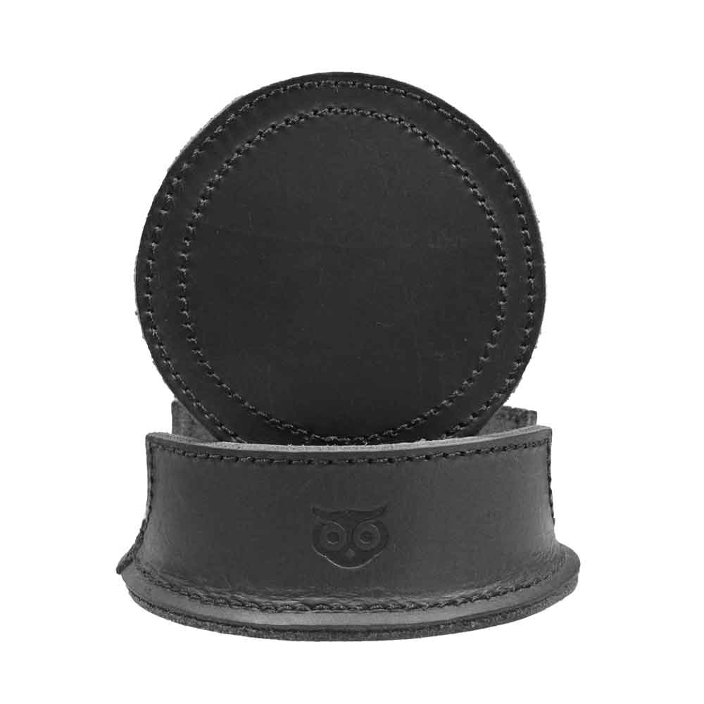 Thick Leather Coasters (6-Pack) by Hide & Drink featuring a circular coaster in charcoal black, highlighting the quality and detail of full grain leather. Ideal for protecting surfaces, these artisan coasters represent small batch production, hand cut, hand sewn, and fire branded, crafted thoughtfully in La Antigua Guatemala.
