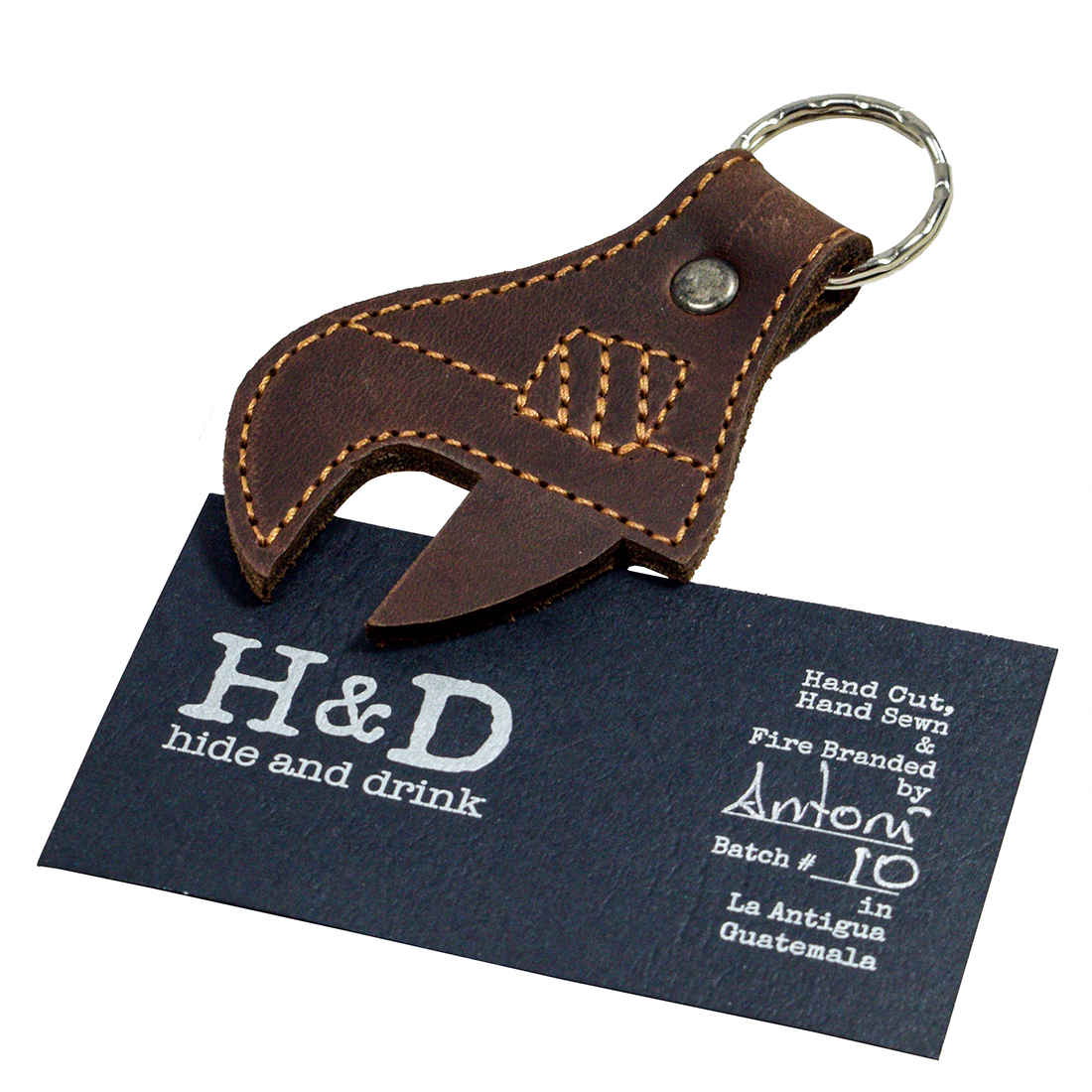 Hide & Drink Wrench Keychain presented with branding information, emphasizing its handcrafted quality and the unique artisan skills from La Antigua Guatemala. Made from Full Grain Leather, this keychain is a stylish and functional tool accessory.