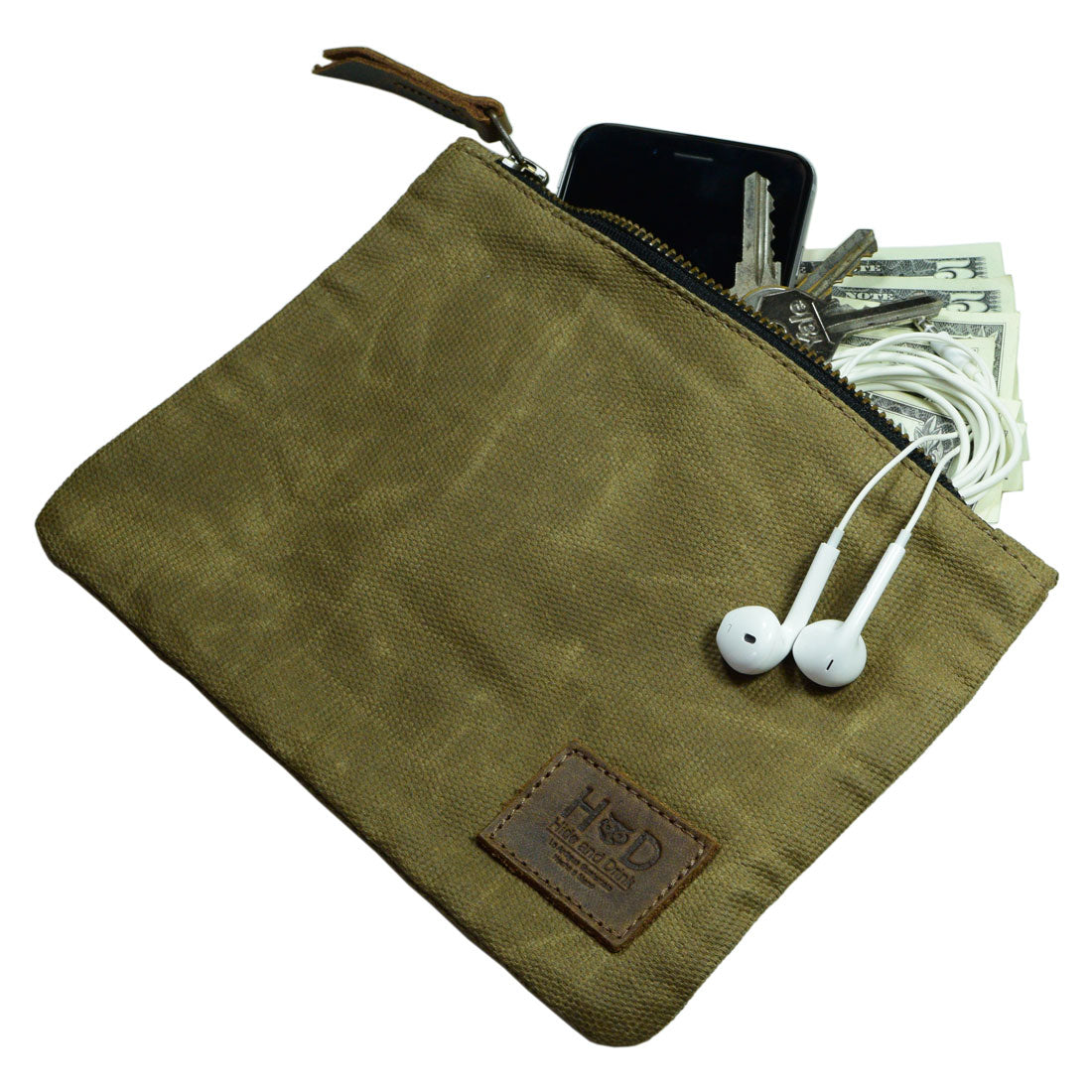 A Waxed Zippered Pouch from Hide & Drink, partially filled with cash and earbuds, demonstrating its versatility as a lightweight case. Made from waxed canvas and full grain leather, this multipurpose bag is handmade in La Antigua Guatemala.