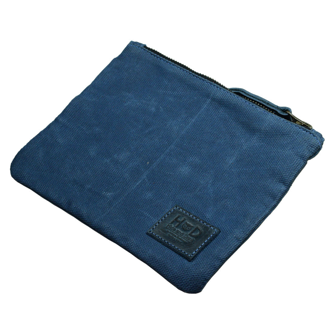An empty blue Waxed Zippered Pouch from Hide & Drink showcasing its sleek design, perfect as a lightweight case. This multipurpose bag is made using artisan techniques from waxed canvas and full grain leather.