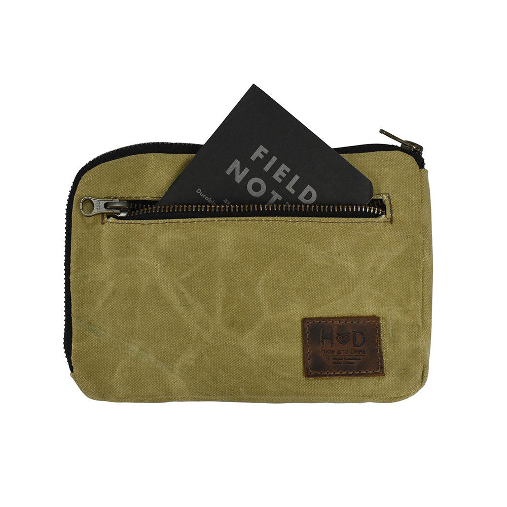 Hide & Drink's Zipper Gear Pouch displaying a sleek design with a Field Notes card, made from water resistant waxed canvas, perfect for organization and travel needs.