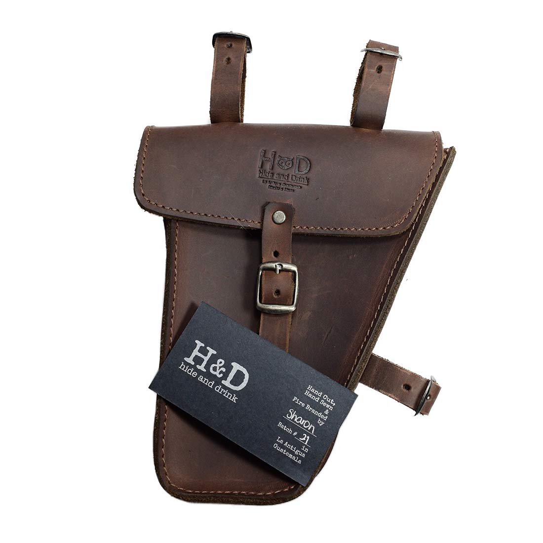 Hide & Drink's Triangular Frame Bag For Bicycle with tag displayed, highlighting its artisan craftsmanship. This Full Grain Leather bike tool pouch is ideal for biker essentials and showcases small batch production from La Antigua Guatemala & Oaxaca Mexico.