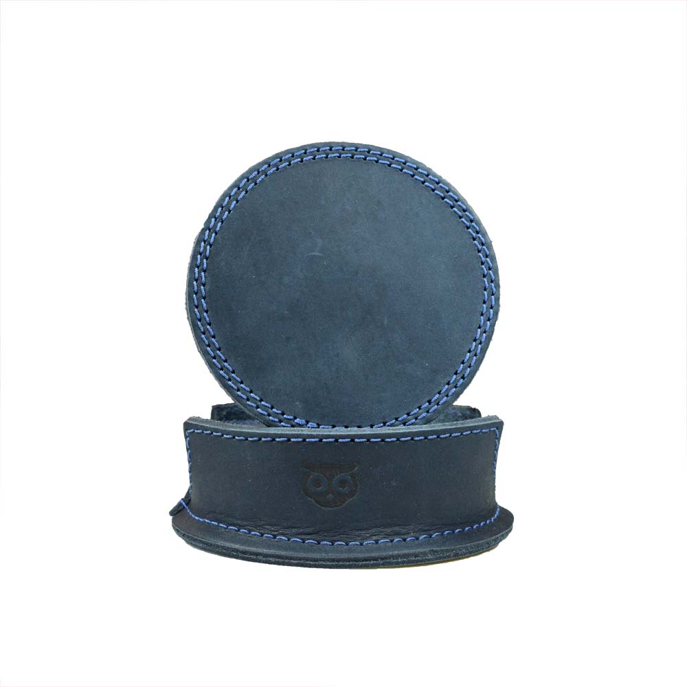 Thick Leather Coasters (6-Pack) by Hide & Drink featuring a circular coaster in blue slate leather, showcasing exquisite craftsmanship. Perfect for any home, these artisan coasters are made from full grain leather and are part of small batch production, hand cut, hand sewn, and fire branded, handmade in La Antigua Guatemala.