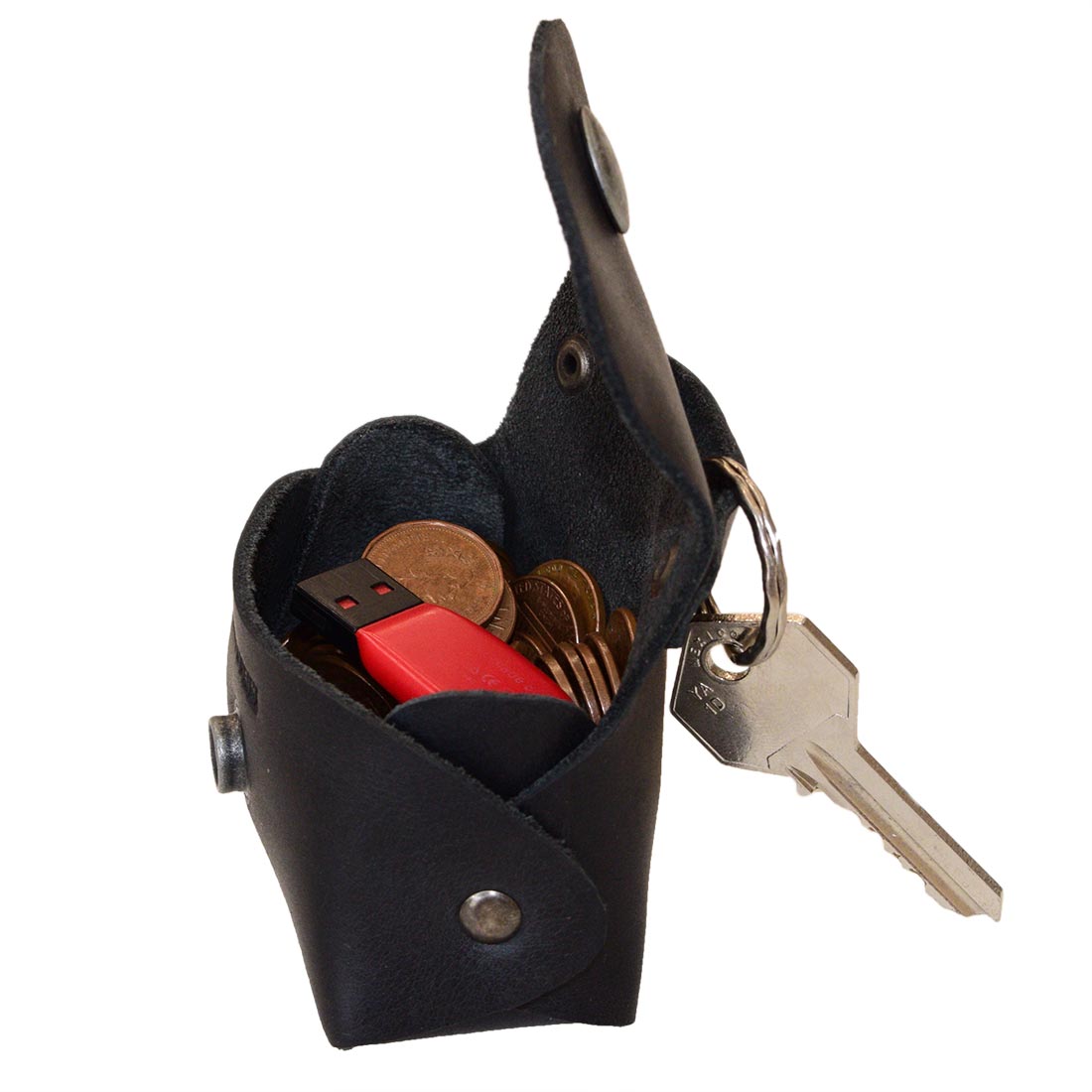 Interior view of the black Tiny Handbag Keychain by Hide & Drink, displaying keys and coins. Crafted from Full Grain Leather, this artisanal product represents small batch production and showcases excellent hand cut and hand sewn craftsmanship.