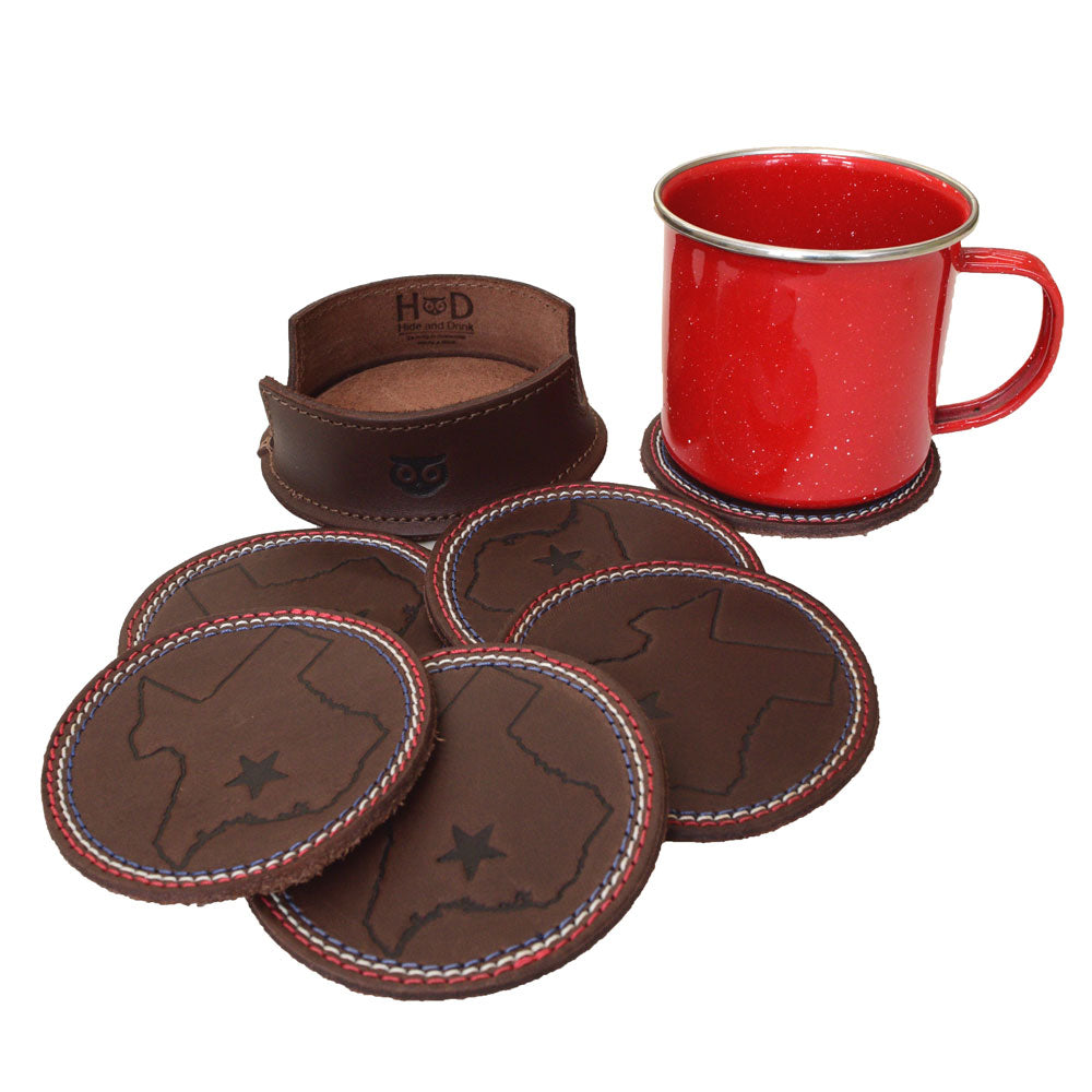 Texas State Coasters with Stitching (6-Pack) by Hide & Drink features a rustic leather coaster set next to a red cup, emphasizing its function as a stylish solution for drinks. Protects surfaces while showcasing Texas pride. Set of 6 Coasters for Drinks with Texas State Design, Glass and Cups Stain Protection, Full Grain Leather, StockyardX, Small Batch Production, Hand Cut, Hand Sewn, Fire Branded, Artisan, Handmade in La Antigua Guatemala & Oaxaca Mexico.
