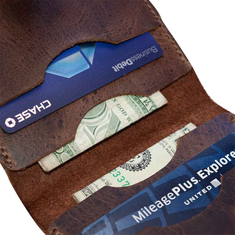 Close-up of the Squared Wallet by Hide & Drink, displaying cards and cash inside its Full Grain Leather structure. This Bifold Simple Wallet is handcrafted with passion, showcasing Small Batch Production and Artisan skills from La Antigua Guatemala.