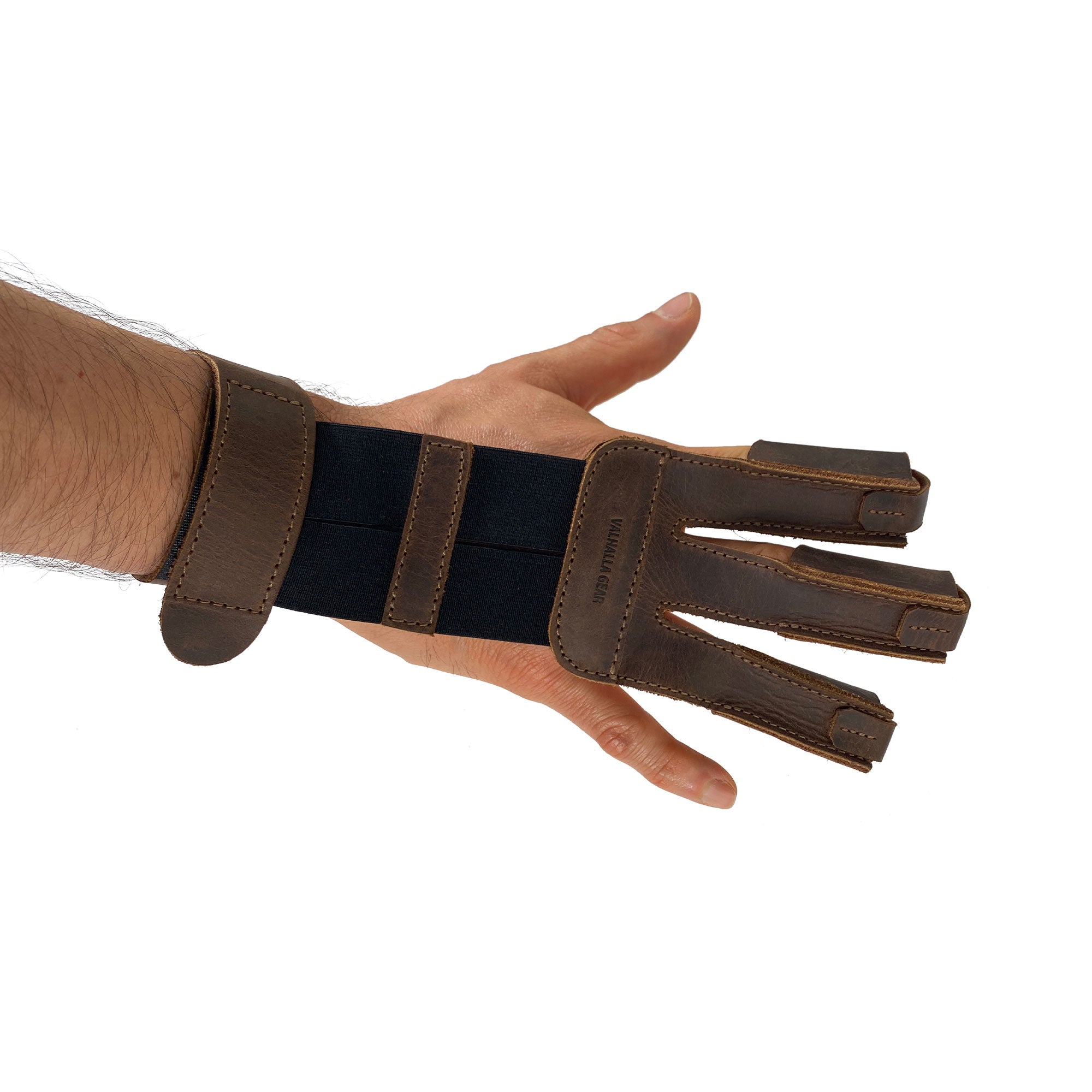 Valhalla Gear Three-Finger Archery Glove worn on a hand, emphasizing its comfort and protection for wrist and fingers, essential for bow and arrow shooting. This accessory, made from full grain leather, combines modern craftsmanship with traditional artisan techniques. Proudly handmade in La Antigua Guatemala & Oaxaca Mexico, it features small batch production, hand cut, hand sewn quality, and is fire branded.