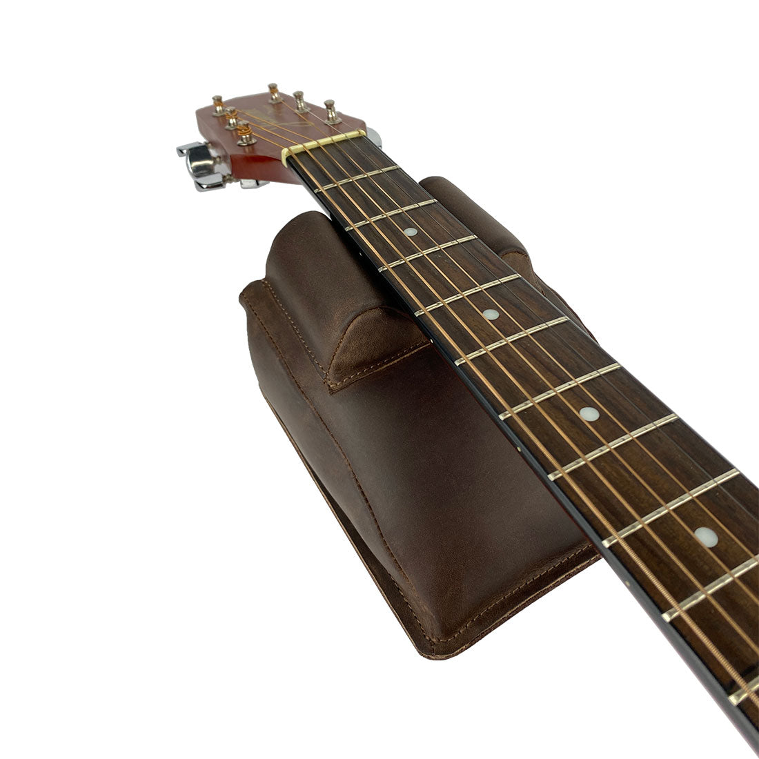 Hide & Drink Guitar Neck Rest supporting a guitar, ideal for string changing and repair. Made from full grain leather, this artisan piece is perfect for musicians looking after their guitars, banjos, and violins, and is a testament to the handmade craft of small batch production in La Antigua Guatemala & Oaxaca Mexico.