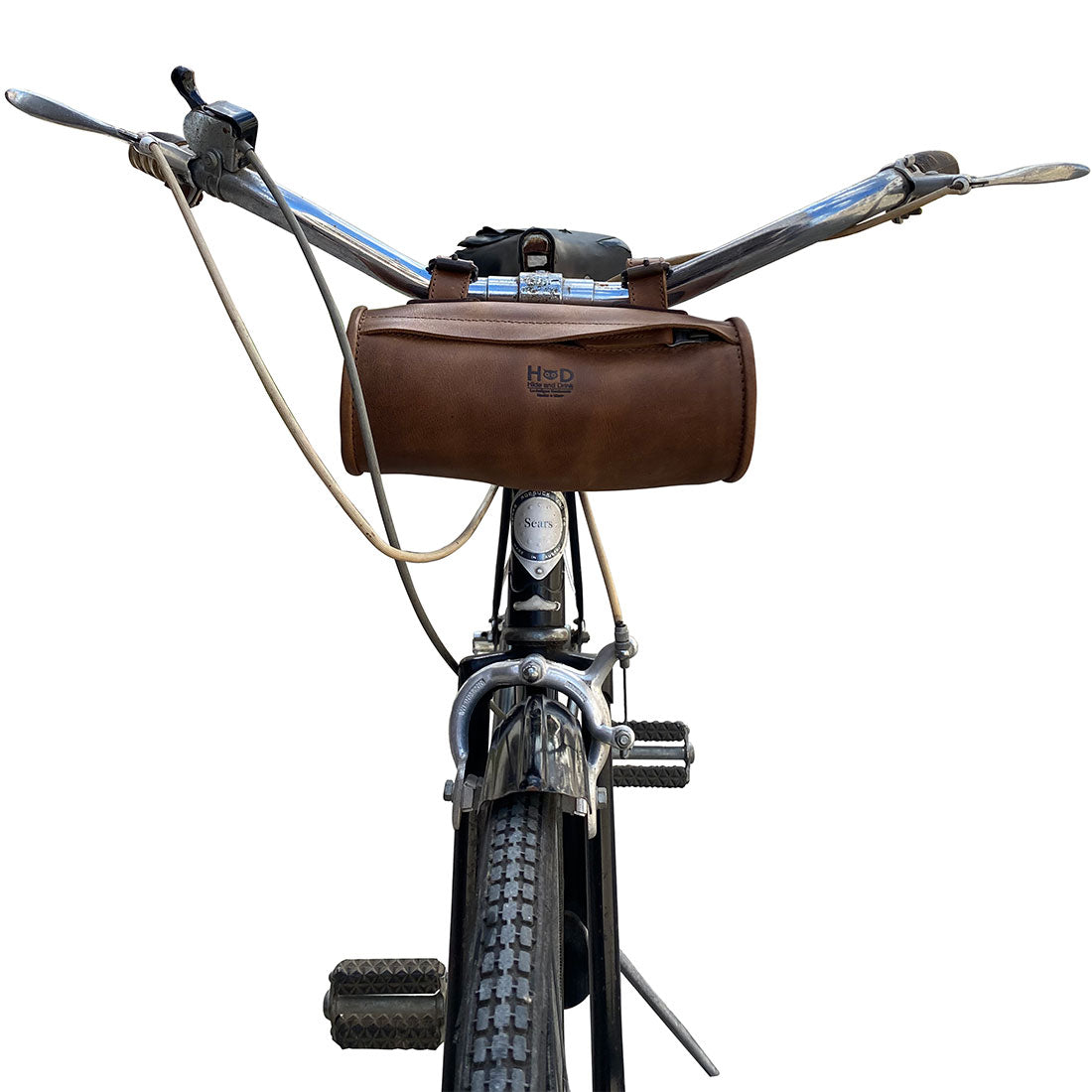 Hide & Drink Bike Bag displayed on a bicycle's handlebars, exemplifying a stylish and functional full grain leather cylinder tube pouch. This unique bicycle accessory is made using artisan techniques, hand cut and hand sewn, crafted in La Antigua Guatemala & Oaxaca Mexico.