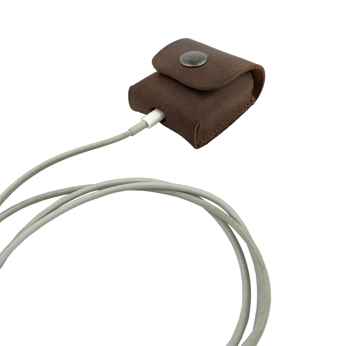 LeatherTex AirPods Case nestled with charging cables, highlighting its dual function as a rustic AirPods charging cover and accessory pouch. This protective portable carrying pouch is handcrafted from full grain leather in La Antigua Guatemala, ensuring an artisan touch.