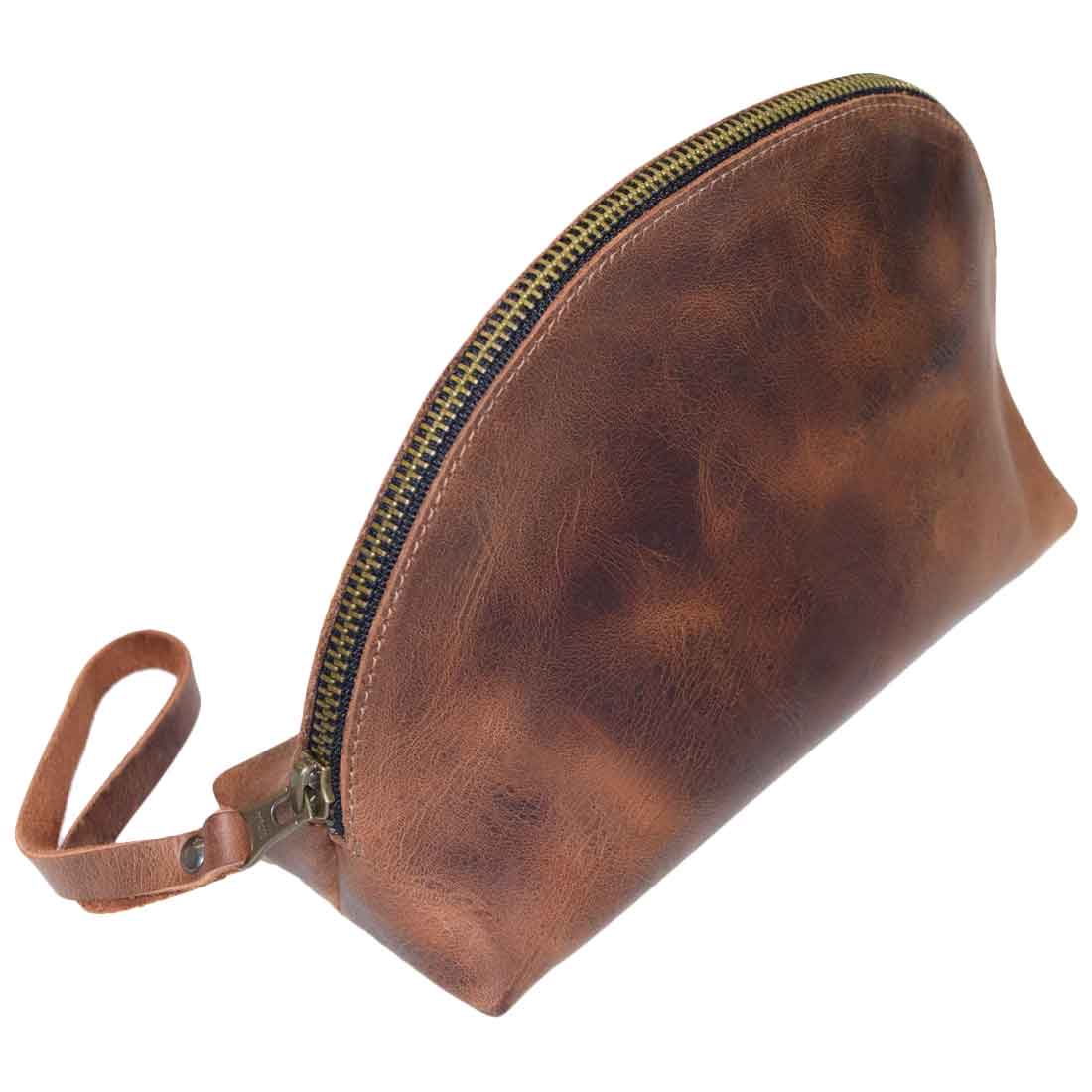 A side view of the Accessory Pouch Organizer Hand Bag made by Hide & Drink, featuring full grain leather and a convenient zipper. This versatile Cosmetic Travel Organizer with Hand Strap for Women doubles as a Makeup Bag and Classic Handbag, showcasing handcrafted quality from La Antigua Guatemala & Oaxaca Mexico.