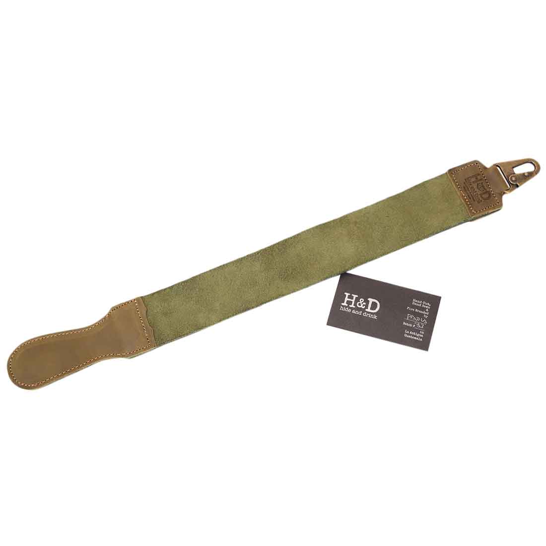 Hide & Drink's Olive Green Barber Strop displayed with a straight razor, perfect for barbers. This handmade Full Grain Leather shaving sharpener merges functionality and artisan craftsmanship.