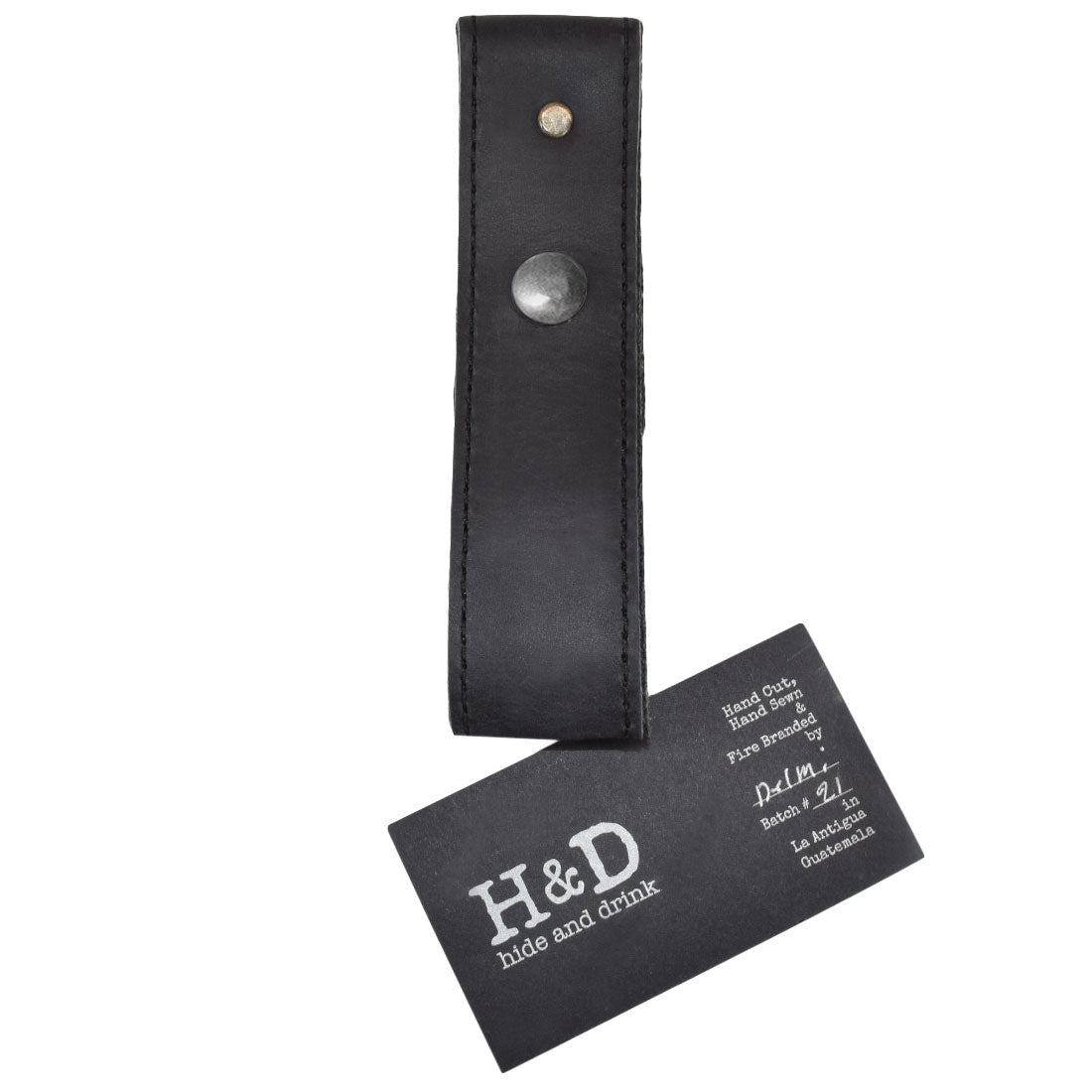 Hide & Drink Whip Holster presented with a tag, showcasing its quality artisan craftsmanship. This stylish Bullwhip Holder, made from Full Grain Leather, embodies Small Batch Production and Handmade artistry from La Antigua Guatemala & Oaxaca Mexico, ideal for any whip enthusiast.