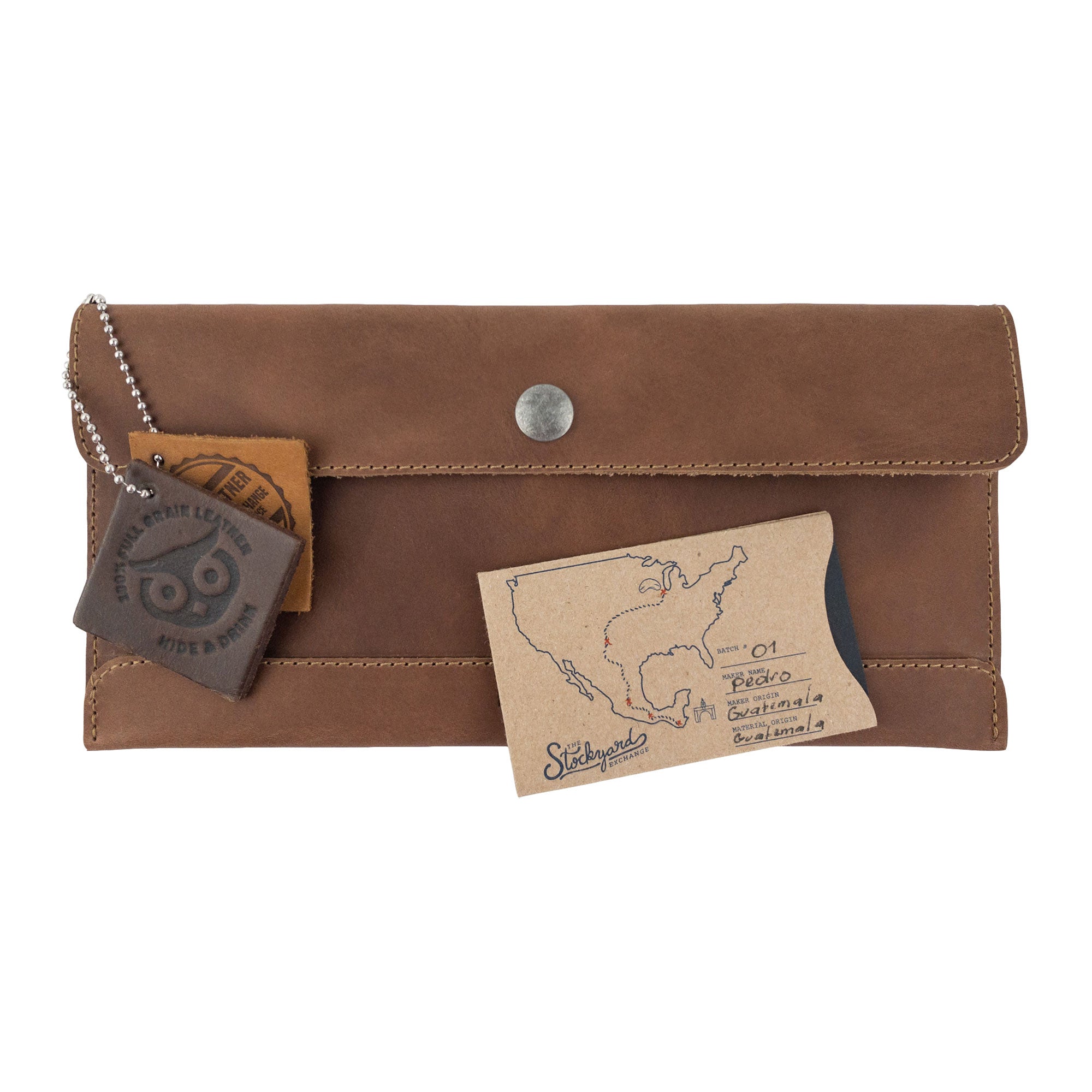 Hide & Drink's brown Travel Hand Wallet displayed with handcrafted accessories, showcasing its beautiful Full Grain Leather. This practical Travel Wallet is a product of artisan craftsmanship, handmade in La Antigua Guatemala & Oaxaca Mexico.