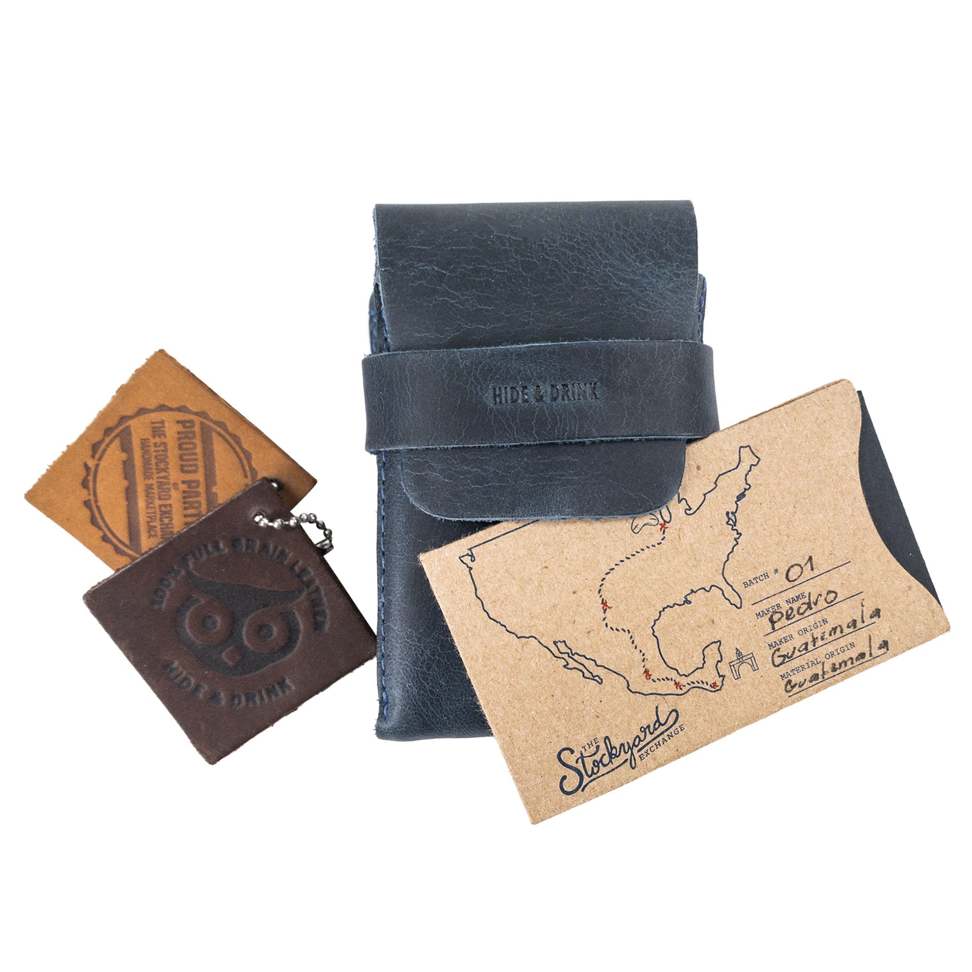 Hide & Drink's navy Playing Card Case featuring an authenticity card and branding. This classic case for playing cards (not included) is perfect for secure storage and travel, crafted from full grain leather by artisans in La Antigua Guatemala. Quality craftsmanship showcased by StockyardX.