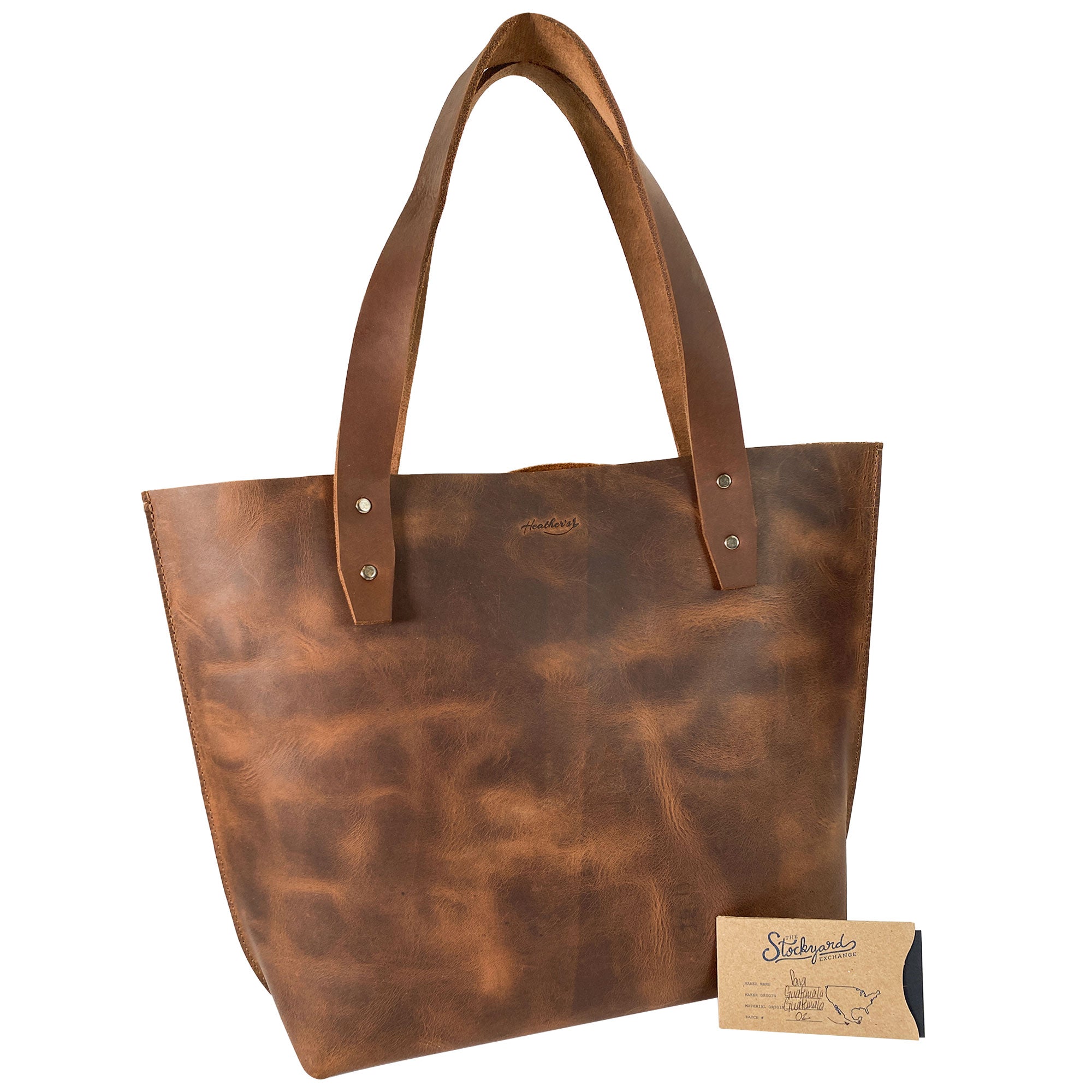 Heather's Minimalist Shoulder Bag displayed with a tag, emphasizing its artisan quality. This Minimalist Handbag Vintage Purse with Handle combines elegance with practicality, crafted from Full Grain Leather, perfect for everyday use and made with care in Guatemala.