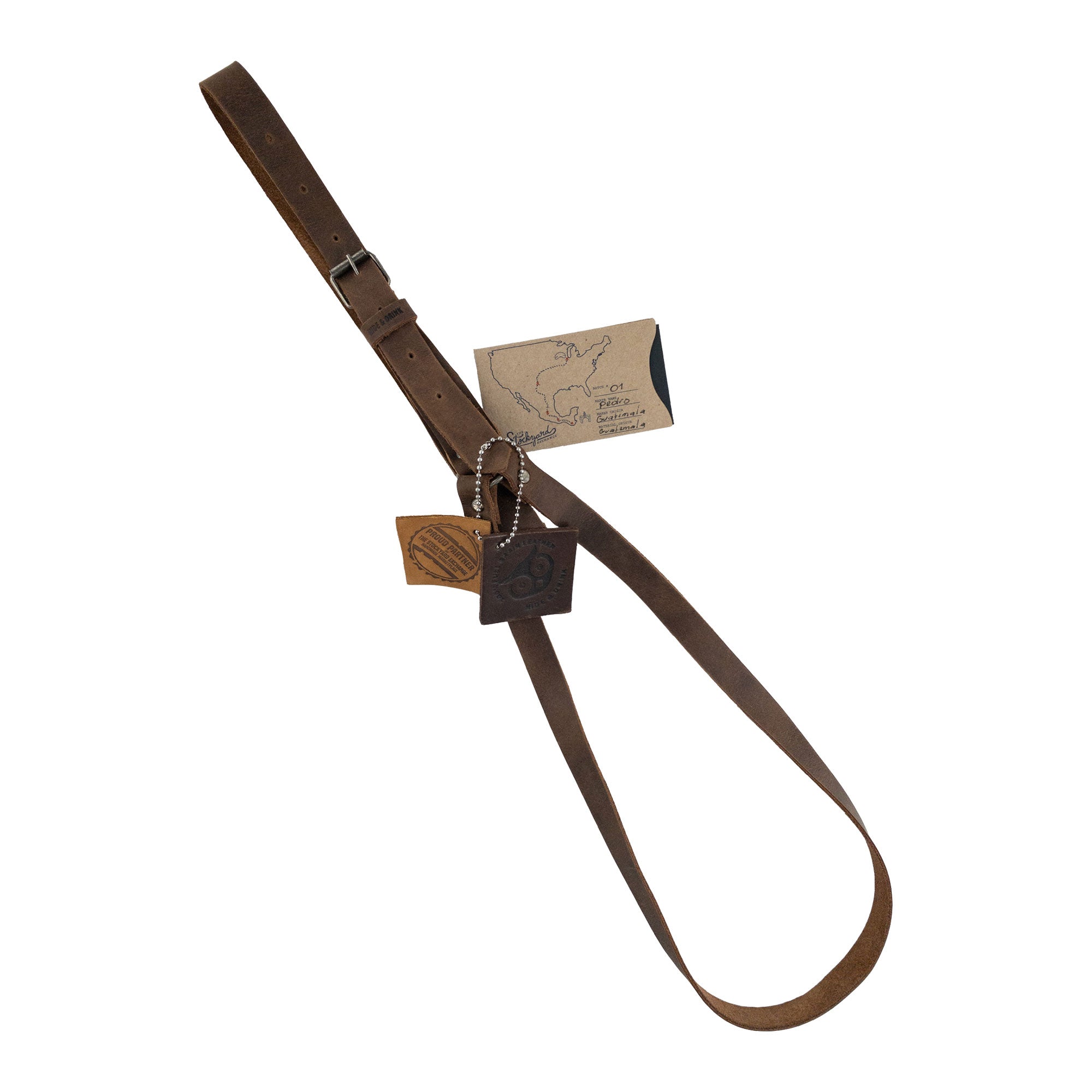 Hat Hanger by Hide & Drink with branding tags, illustrating its authenticity and craftsmanship. Made from full grain leather, this travel accessory blends functionality with a minimalist style, showcasing small batch production and artisan techniques from La Antigua Guatemala & Oaxaca Mexico.