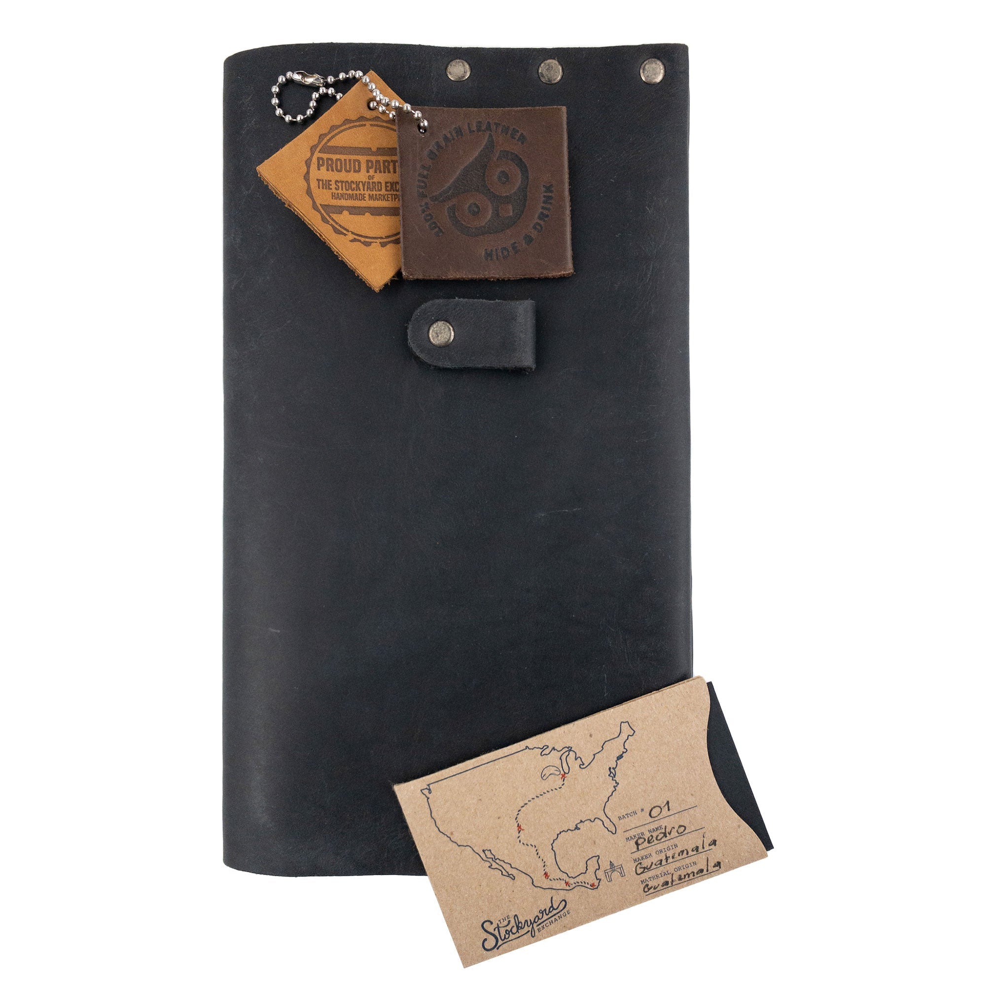 Riveted Journal Cover (5 x 8.50 in.) by Hide & Drink, presented upright with additional accessories, emphasizing its vintage style and full grain leather quality. This handmade product highlights small batch production, hand cut and sewn craftsmanship, created in La Antigua Guatemala & Oaxaca Mexico.
