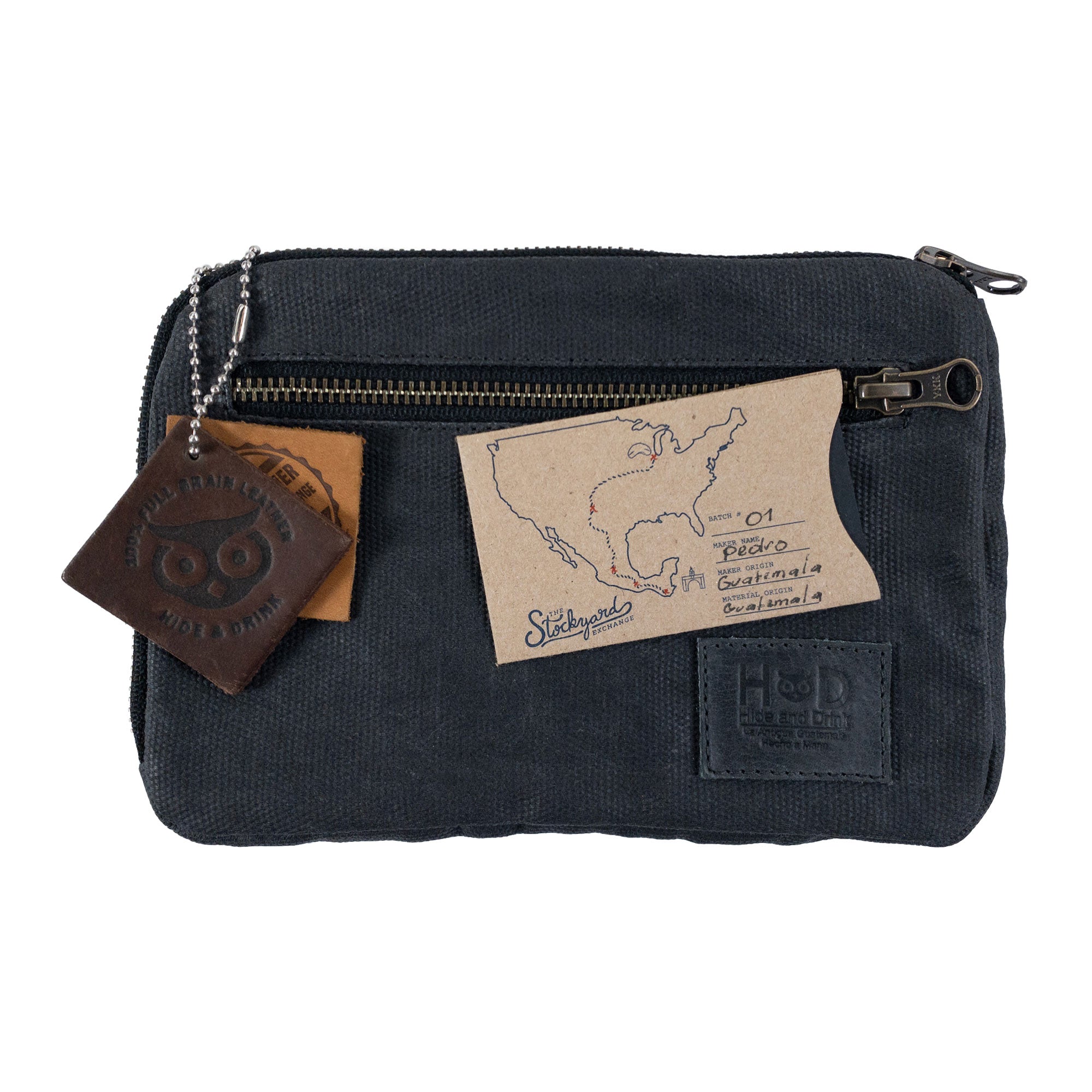 Hide & Drink's Zipper Gear Pouch adorned with artisan tags pinpointing its handmade origin, showcasing the craftsmanship involved in creating this water resistant waxed canvas pouch.