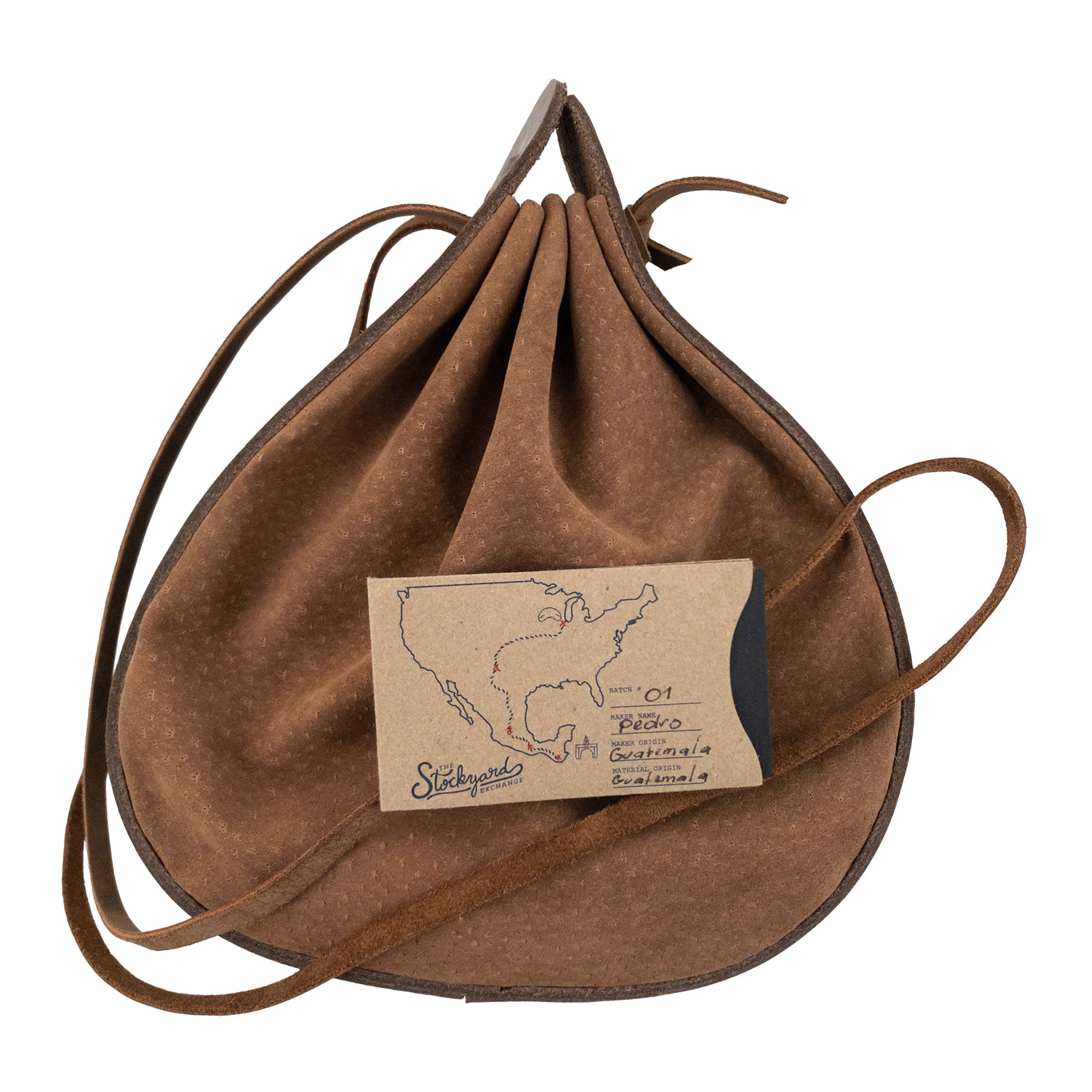 Heather's Shoulder Bag with branded tag, emphasizing its artisan credentials. This multipurpose rounded shoulder bag is made from full grain leather, suitable for travel. It reflects small batch production, hand cut and hand sewn attributes, and is fire branded, showcasing handmade quality from La Antigua Guatemala & Oaxaca Mexico.