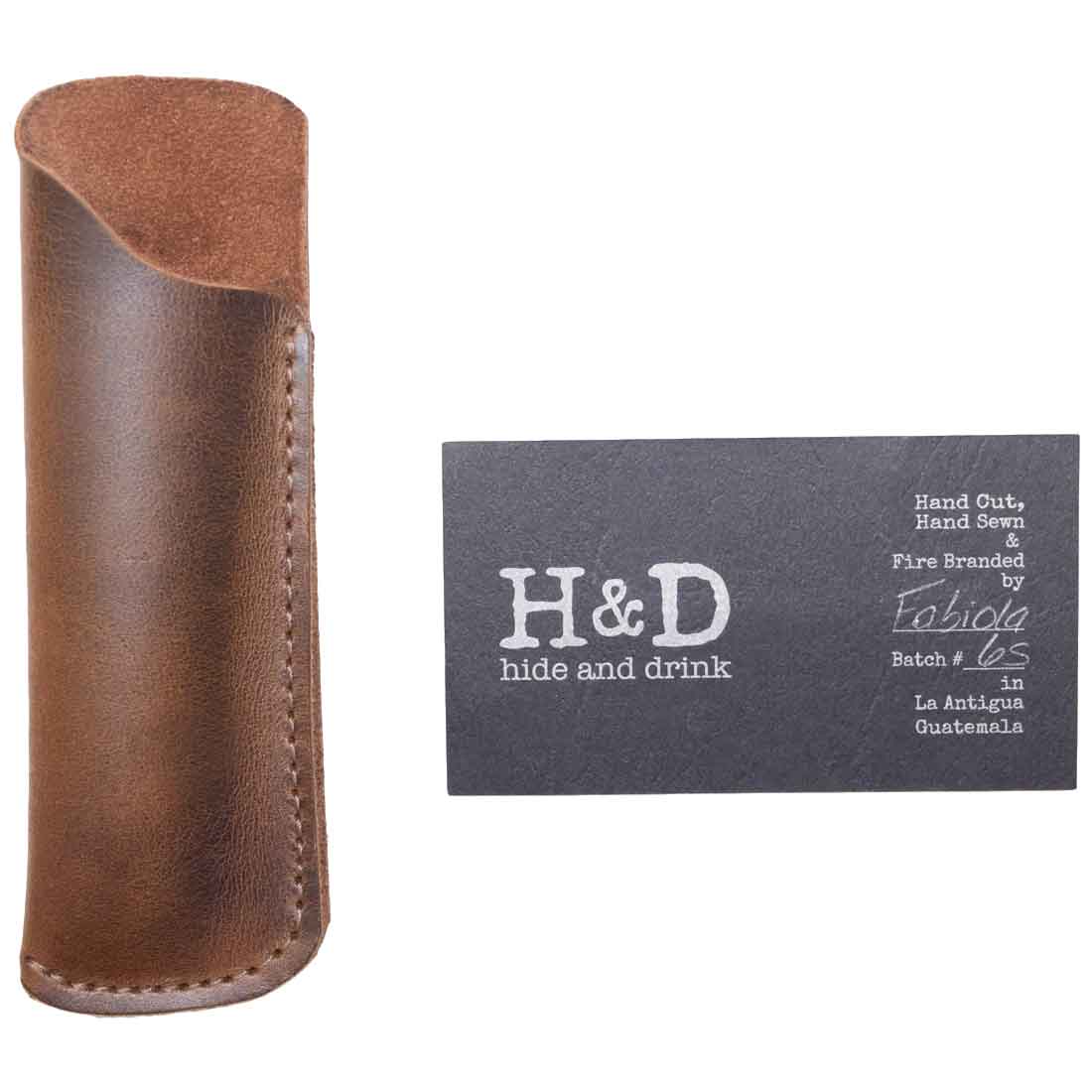 Hide & Drink Comb Case alongside a branding card, reflecting its artisan quality and rustic appeal. This stylish holster is made for protecting your comb in personal care routines. Crafted from full grain leather, embodying small batch production. Handmade in La Antigua Guatemala & Oaxaca Mexico.