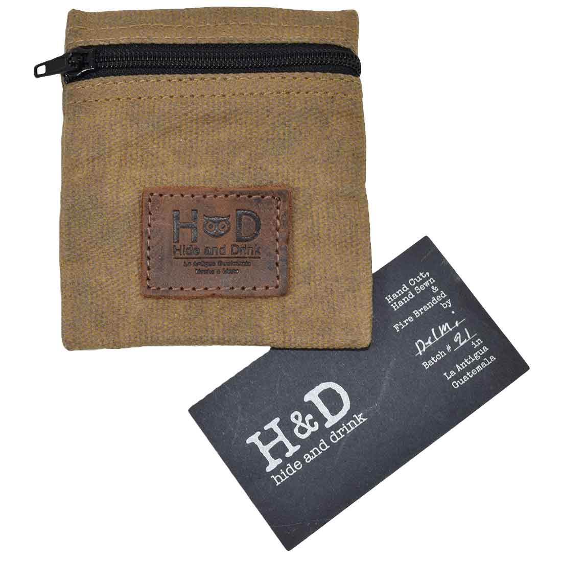 Hide & Drink Condom Pouch alongside a branding card, made from premium water resistant waxed canvas. Ideal for keeping valuables organized, this classic partner gift is perfect for travel and honeymoon essentials. Handmade in La Antigua Guatemala with hand cut, hand sewn craftsmanship.