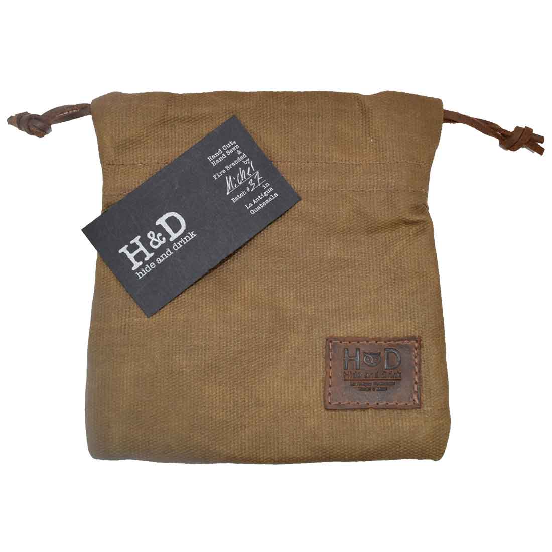 Hide & Drink Golf Pouch displaying a business card, showcasing its elegant design and handmade quality. This waxed canvas pouch is suitable for storing valuables in your golf bag. Waxed Canvas Golf Valuables Field Pouch, Golf Bag, Sport Organizer, Multipurpose Pouch with String, StockyardX, Small Batch Production, Hand Cut, Hand Sewn, Fire Branded, Artisan, Handmade in La Antigua Guatemala & Oaxaca Mexico.