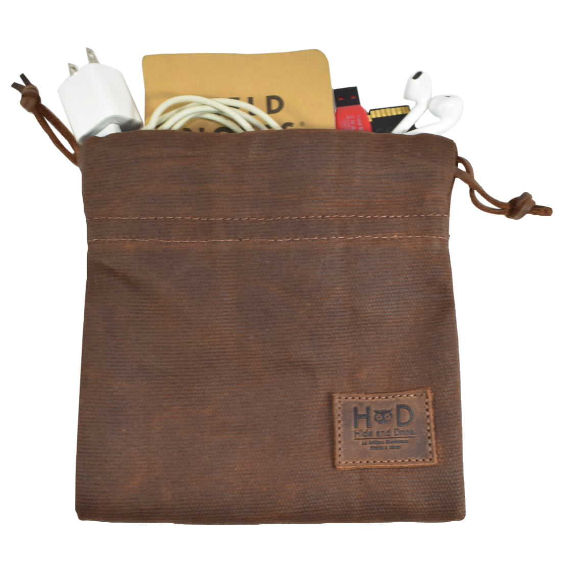 The Hide & Drink Golf Pouch filled with tech accessories, demonstrating its multipurpose functionality. This handcrafted waxed canvas pouch is ideal for keeping cords organized within your golf bag. Waxed Canvas Golf Valuables Field Pouch, Golf Bag, Sport Organizer, Multipurpose Pouch with String, StockyardX, Small Batch Production, Hand Cut, Hand Sewn, Fire Branded, Artisan, Handmade in La Antigua Guatemala & Oaxaca Mexico.