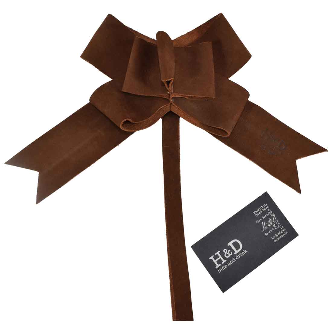 Delightful Suede Leather Ribbon Decor by Hide & Drink featuring a handcrafted bow design ideal for Christmas gift wrapping. This artisan Bow Wrap emphasizes quality with Full Grain Leather, small batch production, hand cut, hand sewn features, fire branded in La Antigua Guatemala and Oaxaca Mexico.