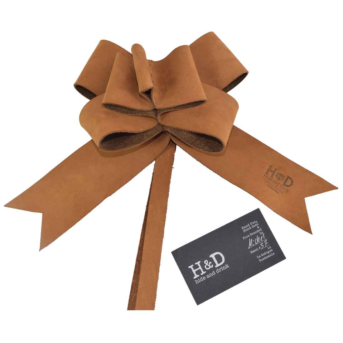 Sophisticated Tan Ribbon Decor by Hide & Drink showcasing a uniquely designed Bow Wrap for Christmas. Crafted from Full Grain Leather, this artisan item emphasizes small batch production, hand cut, and hand sewn qualities, fire branded in La Antigua Guatemala and Oaxaca Mexico.