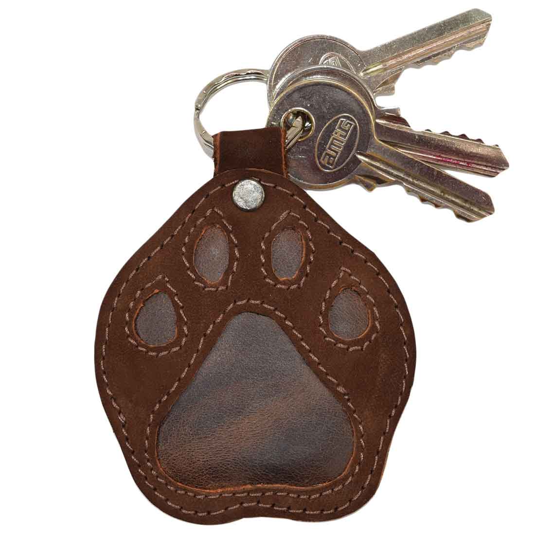 Close-up of the Hide & Drink Doggy Paw Keychain showcasing the cute design, made from full grain leather. This stylish keychain is perfect for dog lovers and features tags like Small Batch Production, Hand Cut, Hand Sewn, and Artisan craftsmanship. A thoughtful gift for any dog lover made in La Antigua Guatemala & Oaxaca Mexico.