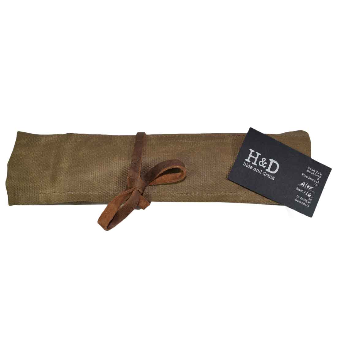 Hide & Drink's Wrench Roll (11 Pockets) rolled neatly with a leather cinch, showcasing its portability. This Wrench Tool Roll provides an ideal hanging storage solution for craftsmen and tool enthusiasts. Made from rugged waxed canvas, it's a classic rustic organizer featuring small batch production, hand cut and hand sewn details, fire branded artistry, handmade in La Antigua Guatemala & Oaxaca Mexico.