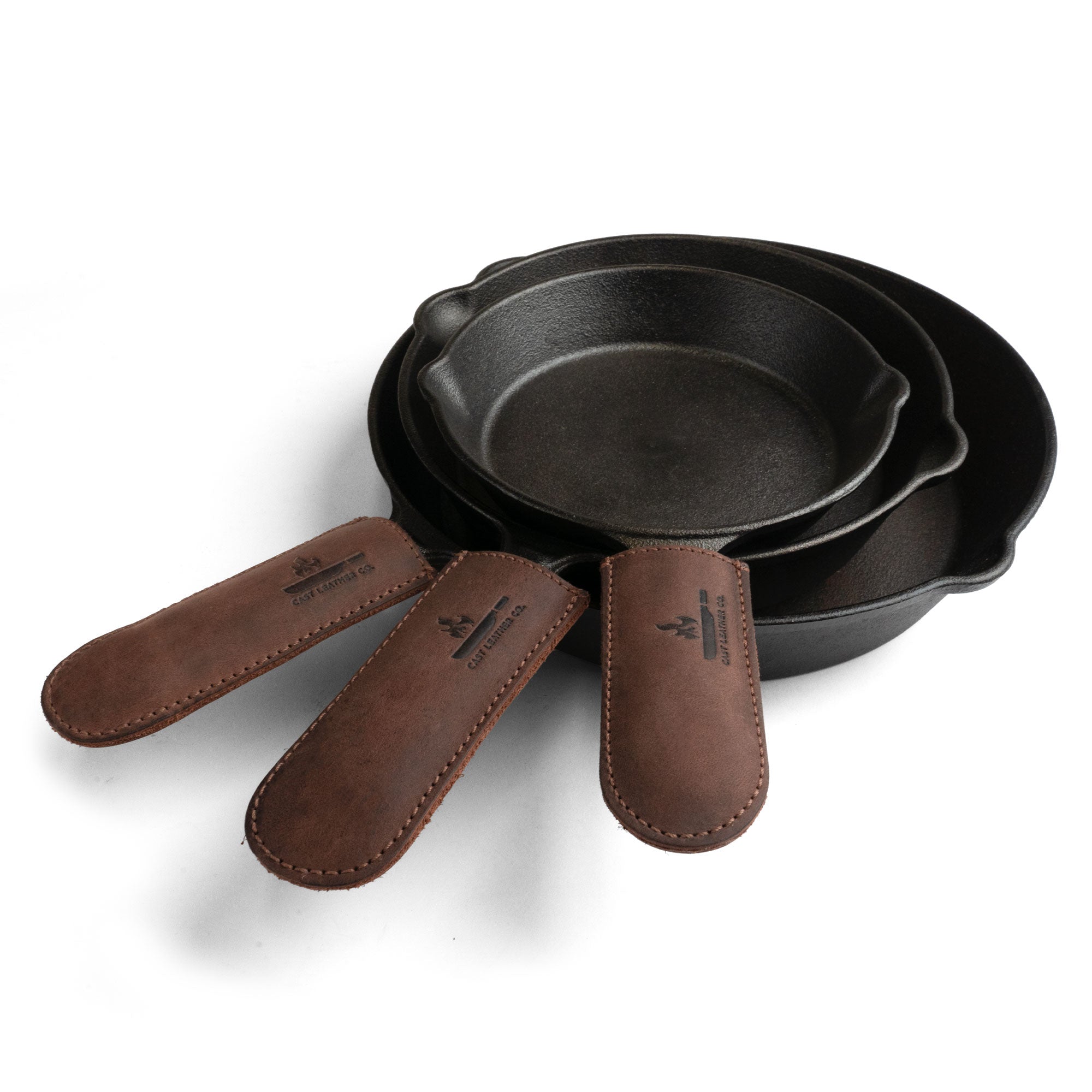 A stylish set of Hot Handle Covers (Set of 3) by Cast Leather Co., featuring full grain leather skillet handle covers designed for cast iron skillets. Ideal for cooking safely, these heat resistant pan handle covers are hand cut, hand sewn, and artisan-crafted in La Antigua Guatemala and Oaxaca Mexico.