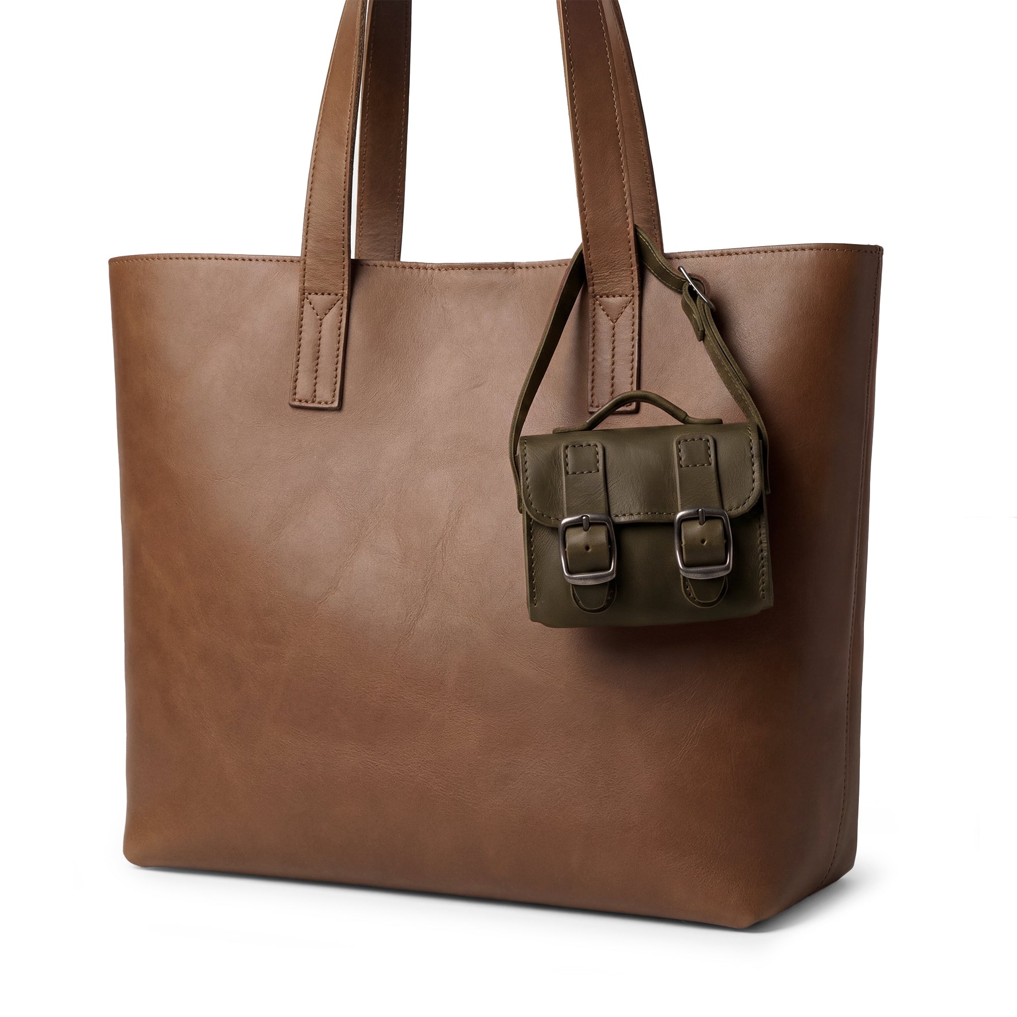 The elegant green Tiny Messenger Bag by Hide & Drink, a unique Mini Messenger Bag Charm crafted from high-quality Full Grain Leather. This artisan piece is perfect as a keychain or handbag accessory, proudly made by hand in La Antigua Guatemala.