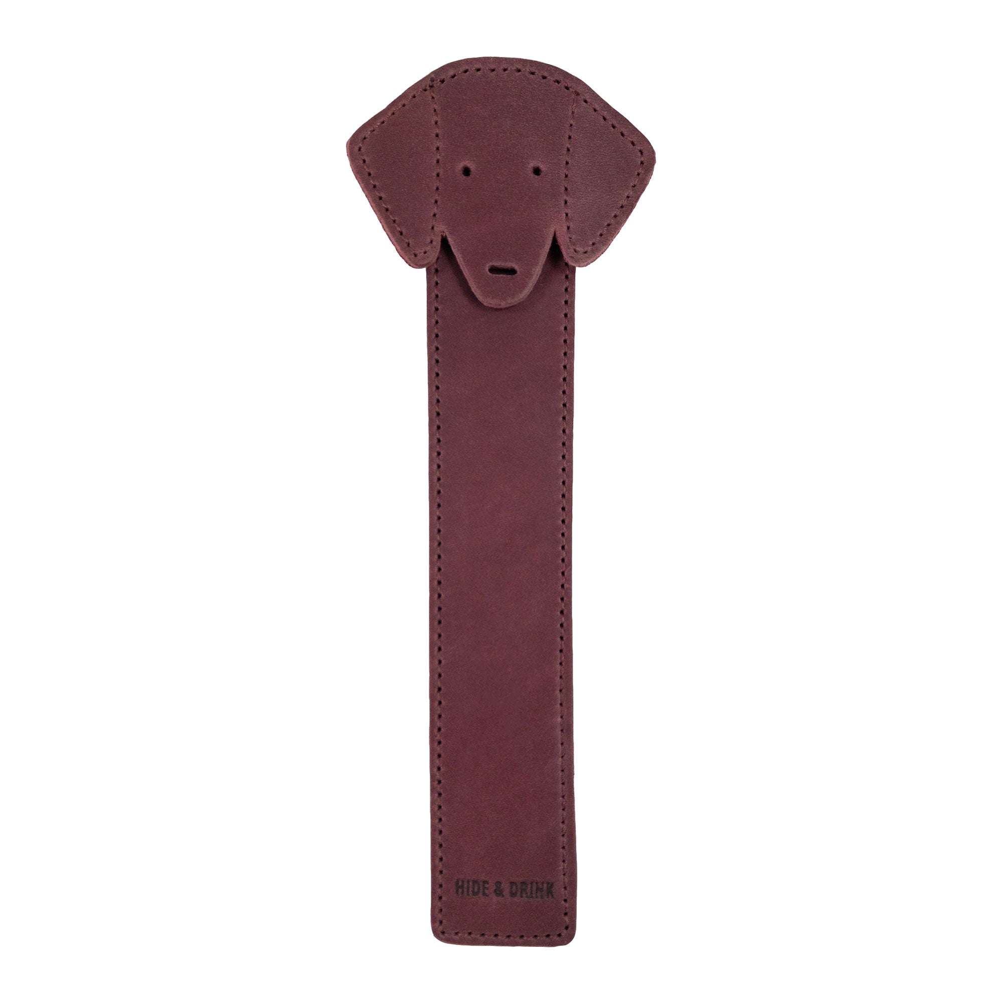 The front view of Hide & Drink's burgundy Dog Bookmark designed in Full Grain Leather, showcasing the unique dog face. This handmade bookmark reflects the quality of small batch production and fire branding, crafted in La Antigua Guatemala & Oaxaca Mexico.