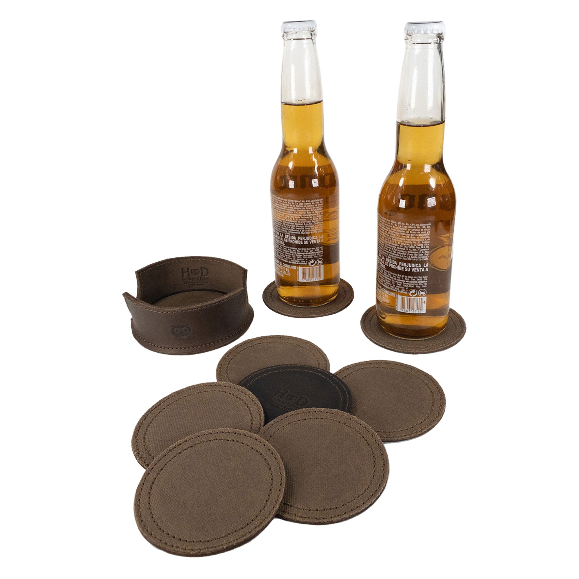 The Set of 8 Circular Coasters for Drinks by Hide & Drink presented with two bottles, made from Waxed Canvas and Full Grain Leather. This set features Glass & Cups Stain Protection and represents StockyardX’s commitment to Small Batch Production with each Handmade piece being Hand Cut, Hand Sewn, Fire Branded, and crafted in Artisan style, Handmade in La Antigua Guatemala & Oaxaca Mexico.