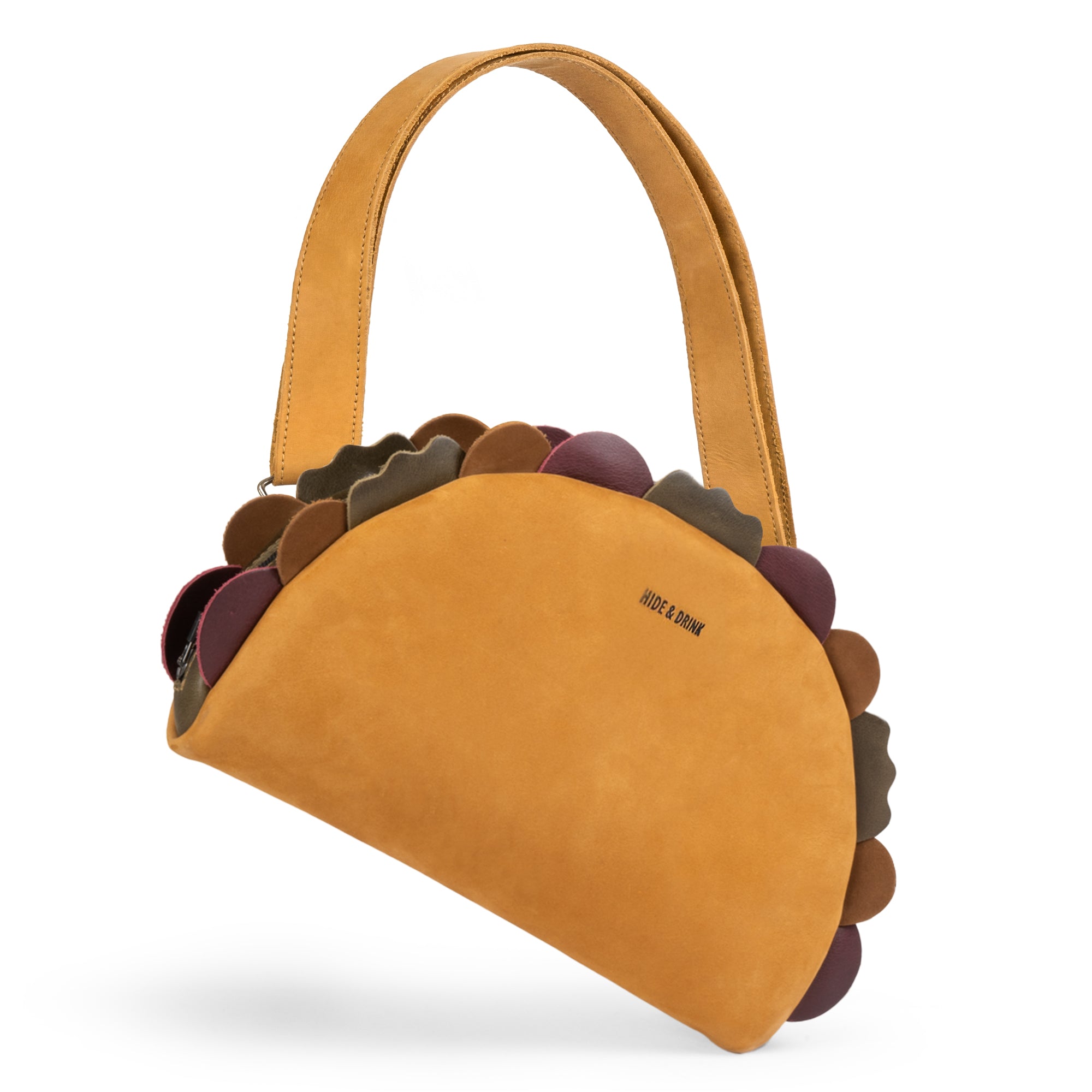 Stylish Taco-Shaped Crossbody Bag by Hide & Drink, featuring leather design and playful scalloped edges. This Leather Taco-Shaped Crossbody Bag with Adjustable Shoulder Strap is ideal for travel as a messenger bag or shoulder bag. Made from full grain leather, it embodies small batch production, being hand cut, hand sewn, and fire branded by artisans from La Antigua Guatemala & Oaxaca Mexico.