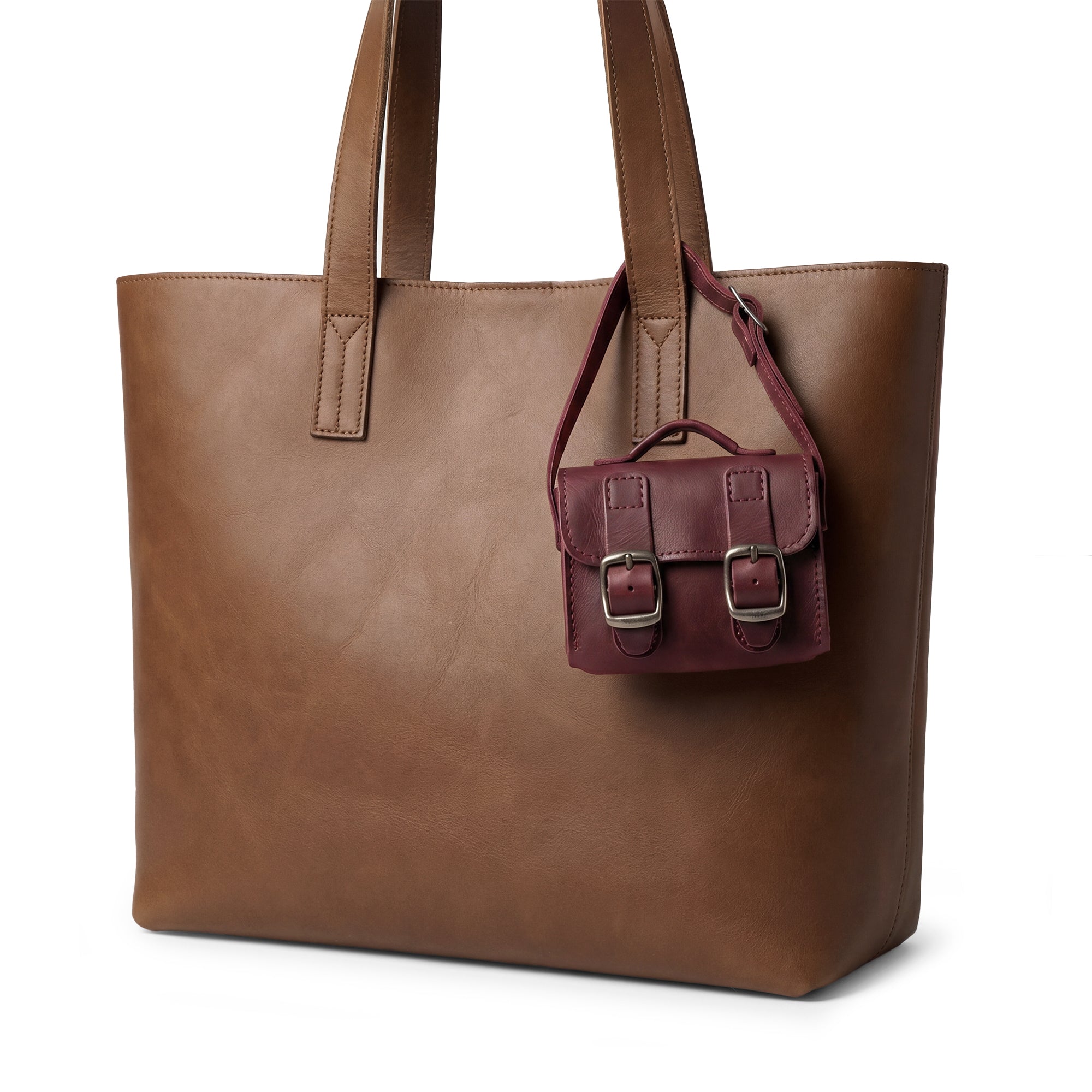 The stunning Tiny Messenger Bag in vibrant burgundy by Hide & Drink, an adorable Mini Messenger Bag Charm made from Full Grain Leather. This artisan design is perfect for handbags or as a unique keychain, showcasing craftsmanship from La Antigua Guatemala.