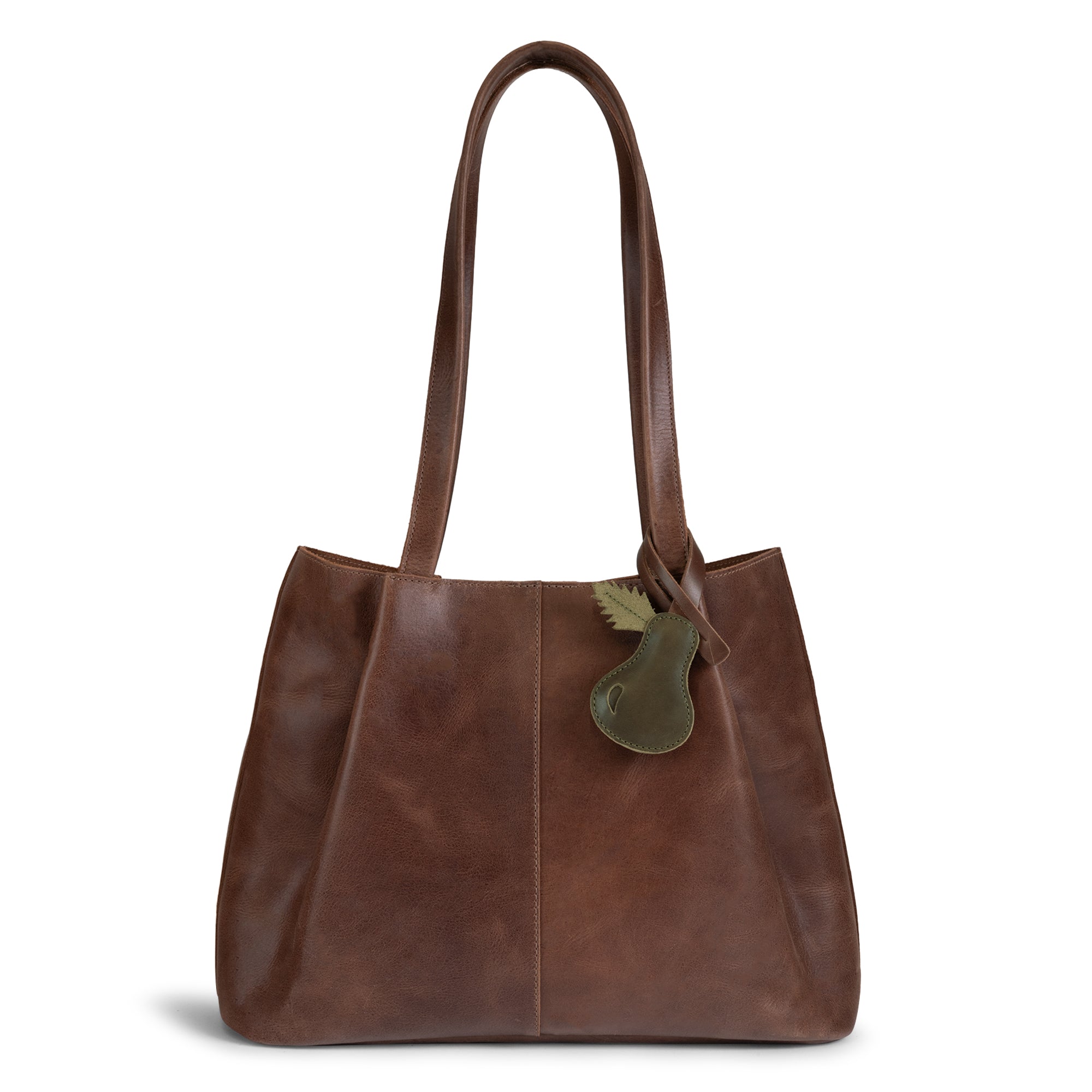 Stylish Pear Bag Charm from Hide & Drink attached to a brown leather handbag, offering a unique touch as a purse charm for totes and backpacks. This full grain leather ornament for women highlights artisan craftsmanship through hand cut and hand sewn techniques, made in La Antigua Guatemala & Oaxaca Mexico.