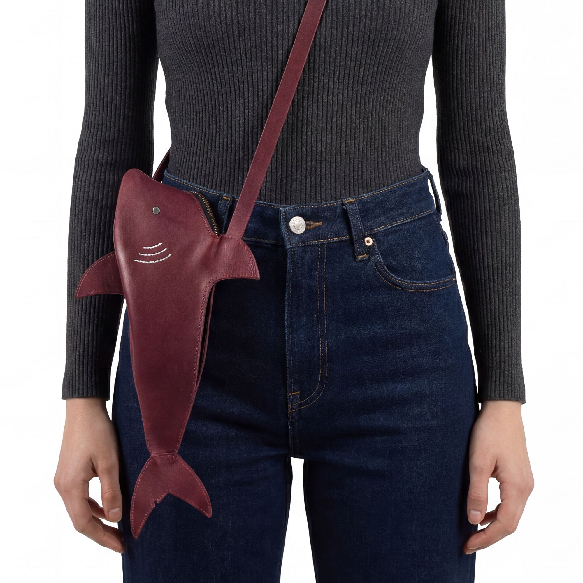 A person modeling the Shark-Shaped Shoulder Bag by Tudi Frudi, showcasing the adjustable strap. This unique bag combines style and practicality, perfect for crossbody or messenger wear. Crafted with Full Grain Leather, it represents artisan, handmade quality from La Antigua Guatemala.