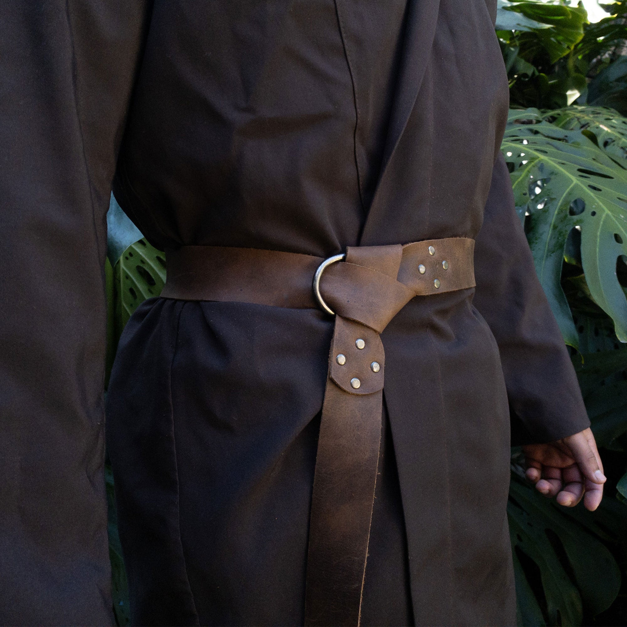 Model wearing a Viking Belt for Men by Valhalla Gear. The belt, made of Full Grain Leather, features a Half Ring Closure, ideal for Renaissance costumes. This artisan-crafted Viking Belt is hand-cut, hand-sewn, and fire branded, showcasing the quality of small batch production in La Antigua Guatemala & Oaxaca Mexico.