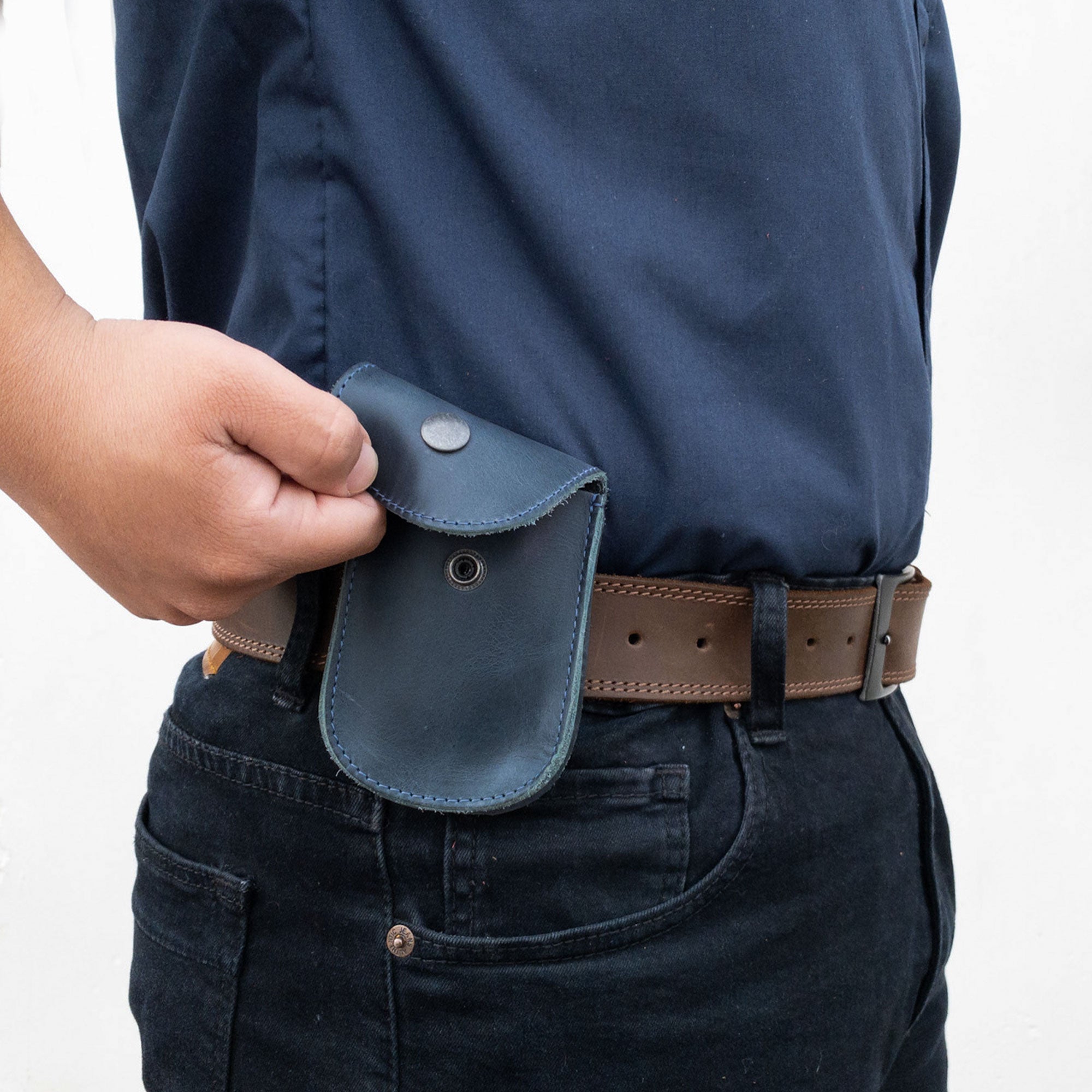 Holster Pouch by Hide & Drink being worn on a belt, highlighting its practical design for everyday use. This handmade pouch, made from full grain leather, is perfect for carrying essential personal items.