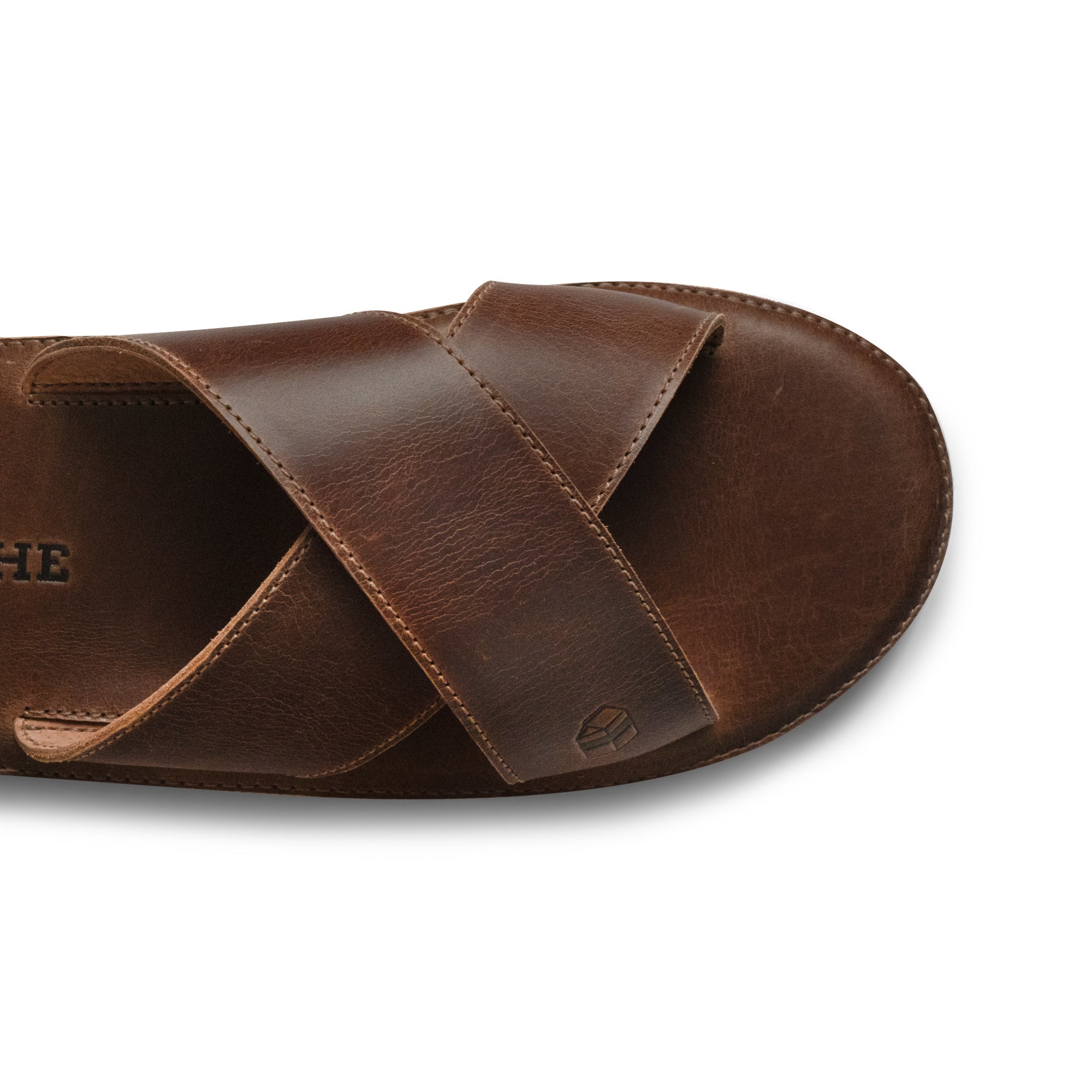 A top view of The Wanderer Arch Comfort Sandals emphasizing the rich texture of the Full Grain Leather material. This product by La Leche combines comfort with style, featuring soft cushion insoles that support every step. Ideal for indoor and outdoor use, these handmade sandals are a testament to quality craftsmanship from Guatemala and Mexico.