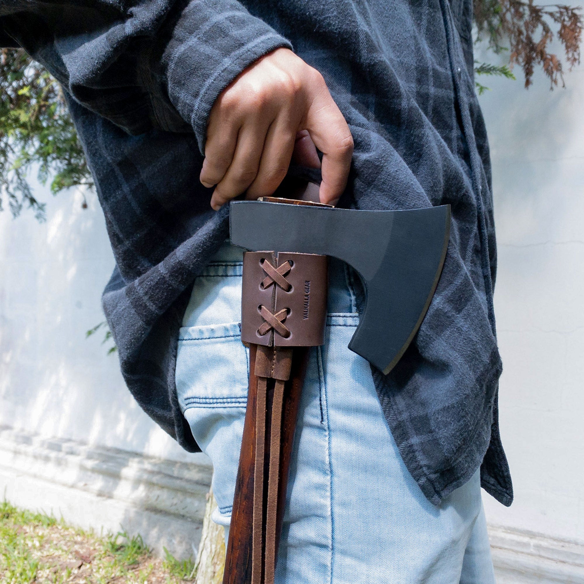 Person wearing a Braided Axe Holder with Belt Loop from Valhalla Gear while holding an axe, demonstrating its functionality as an outdoor accessory. This handmade piece, made from full grain leather, is ideal for camping, cosplay, and lumberjack enthusiasts.
