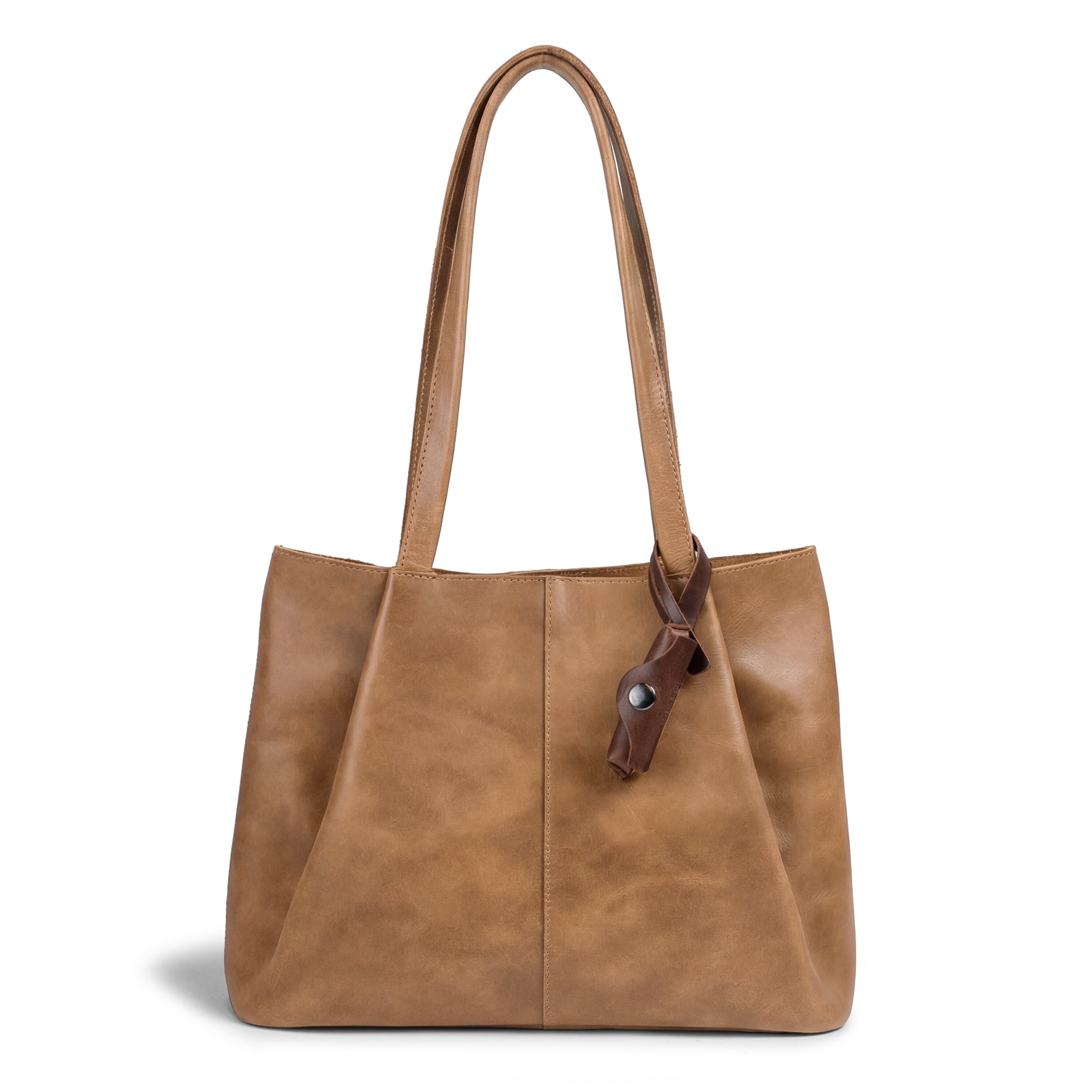 A beautiful handbag featuring the Hide & Drink Lip Balm Holder Bag Charm, ideal for enhancing your style as a Lip Balm Charm for Handbags, Purse Charm for Tote & Backpacks. This ornament is handmade from full grain leather, showcasing artisan craftsmanship from La Antigua Guatemala & Oaxaca Mexico.