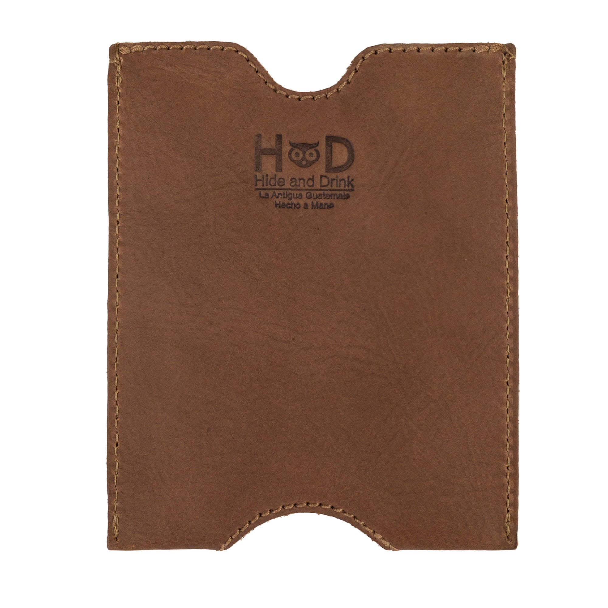 The Hide & Drink Passport Sleeve in a rich brown hue, features a fire branded logo. This handmade travel passport pocket sleeve is crafted from full grain leather, perfect for the stylish traveler. Features tags: Travel Passport Pocket Sleeve, Full Grain Leather, StockyardX, Small Batch Production, Hand Cut, Hand Sewn, Fire Branded, Artisan, Handmade in La Antigua Guatemala & Oaxaca Mexico.