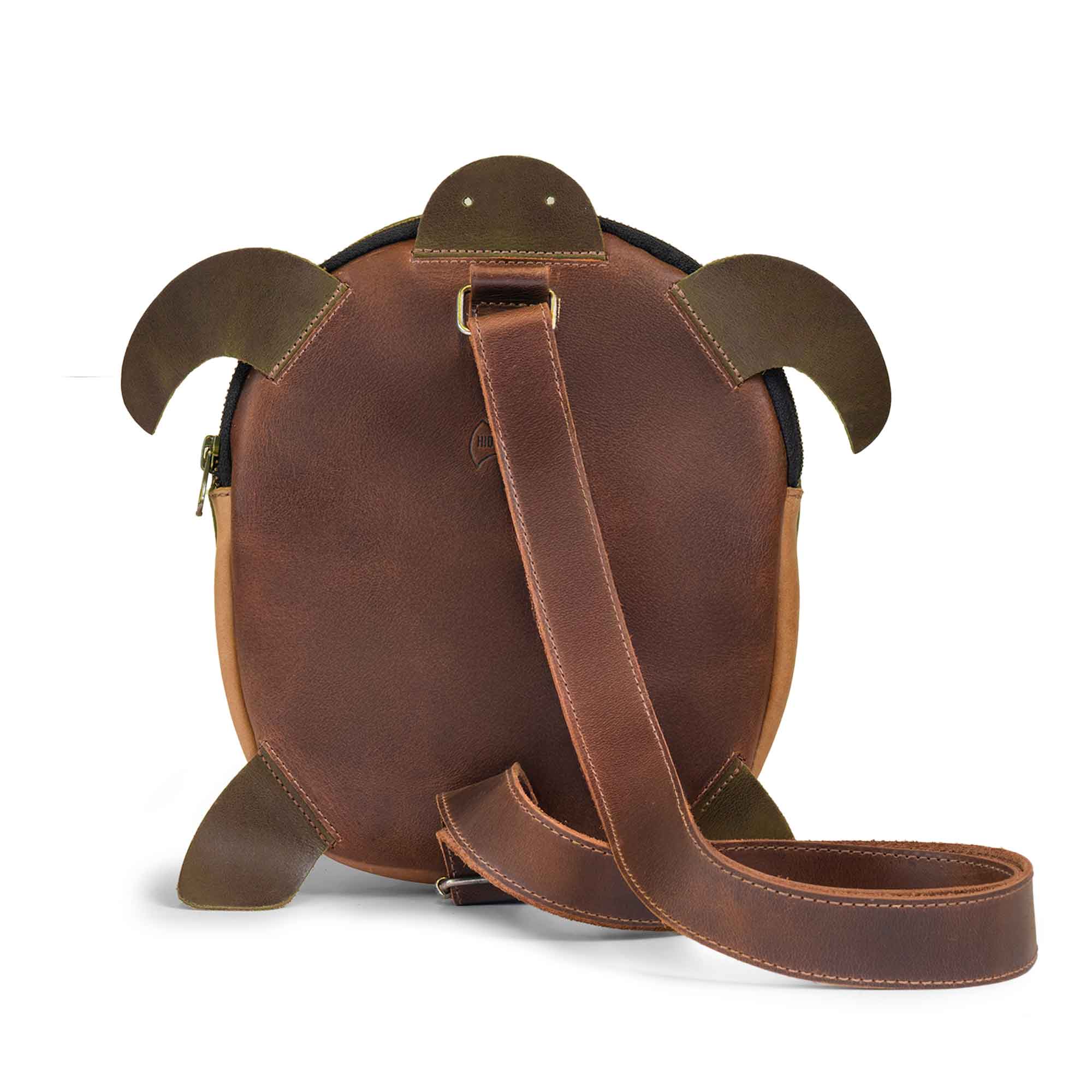 Back view of the Leather Turtle-Shaped Crossbody Bag by Hide & Play, highlighting its adjustable shoulder strap. Ideal as a messenger bag or shoulder bag, this zippered sling bag is crafted from full grain leather for durability. Handmade in La Antigua Guatemala & Oaxaca Mexico through small batch production techniques.