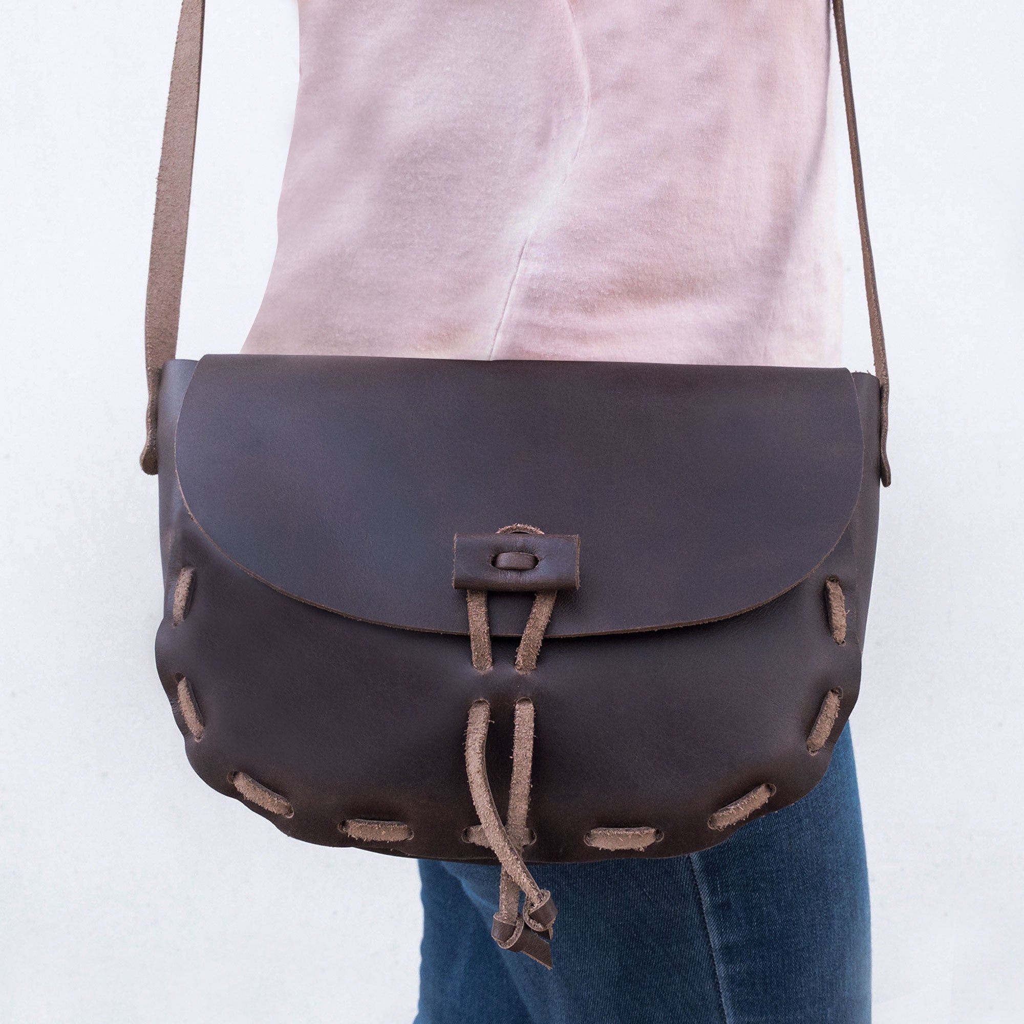 Model carrying a Medieval Style Shoulder Bag by La Antigua. This crossbody bag highlights its unique design and practicality for daily use. Made of Full Grain Leather, this handmade artisan product showcases the craftsmanship of small batch production and is crafted in La Antigua Guatemala & Oaxaca Mexico.