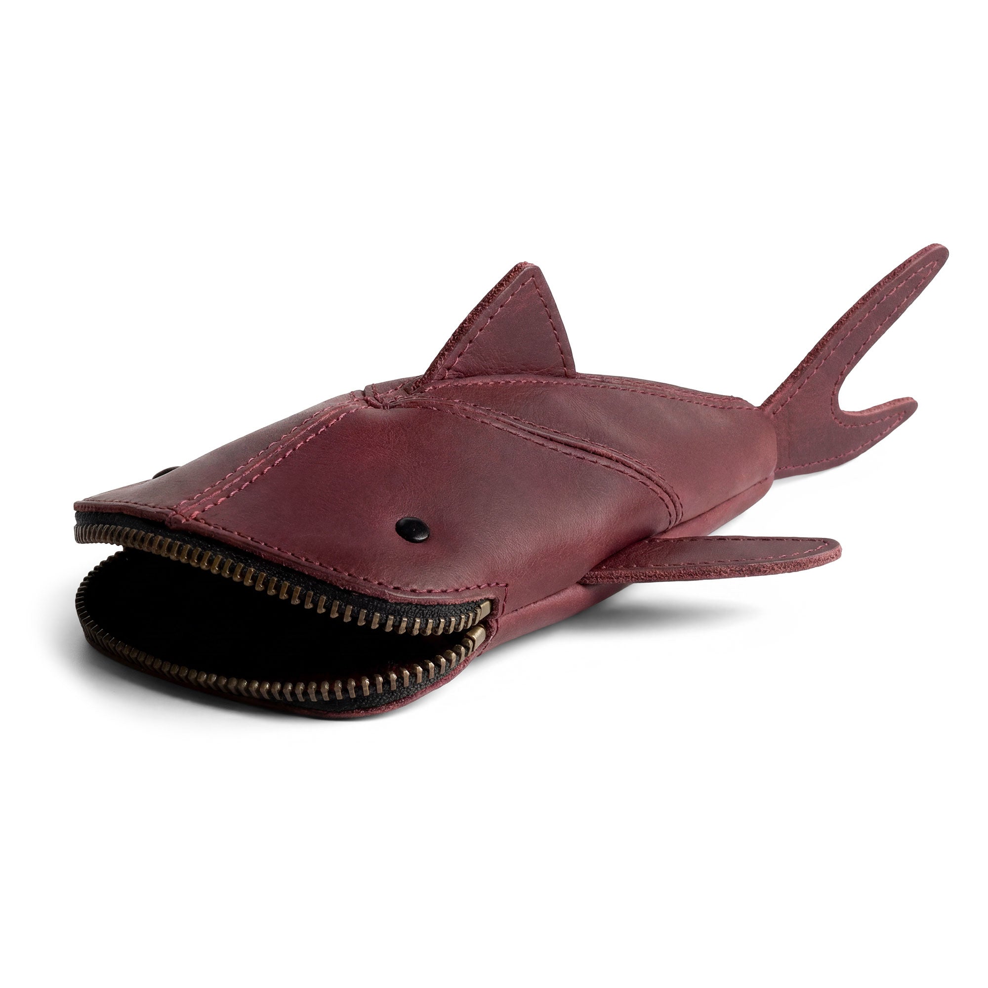 Close-up of the Hide & Drink Leather Shark Pouch highlighting its sleek design and quality craftsmanship. This versatile leather pouch serves as a pencil purse, scissors case, and makeup holder, perfect for storing essentials while being a stylish shark-shaped wallet. Handmade in La Antigua Guatemala & Oaxaca Mexico with a focus on small batch production and artisanal details.