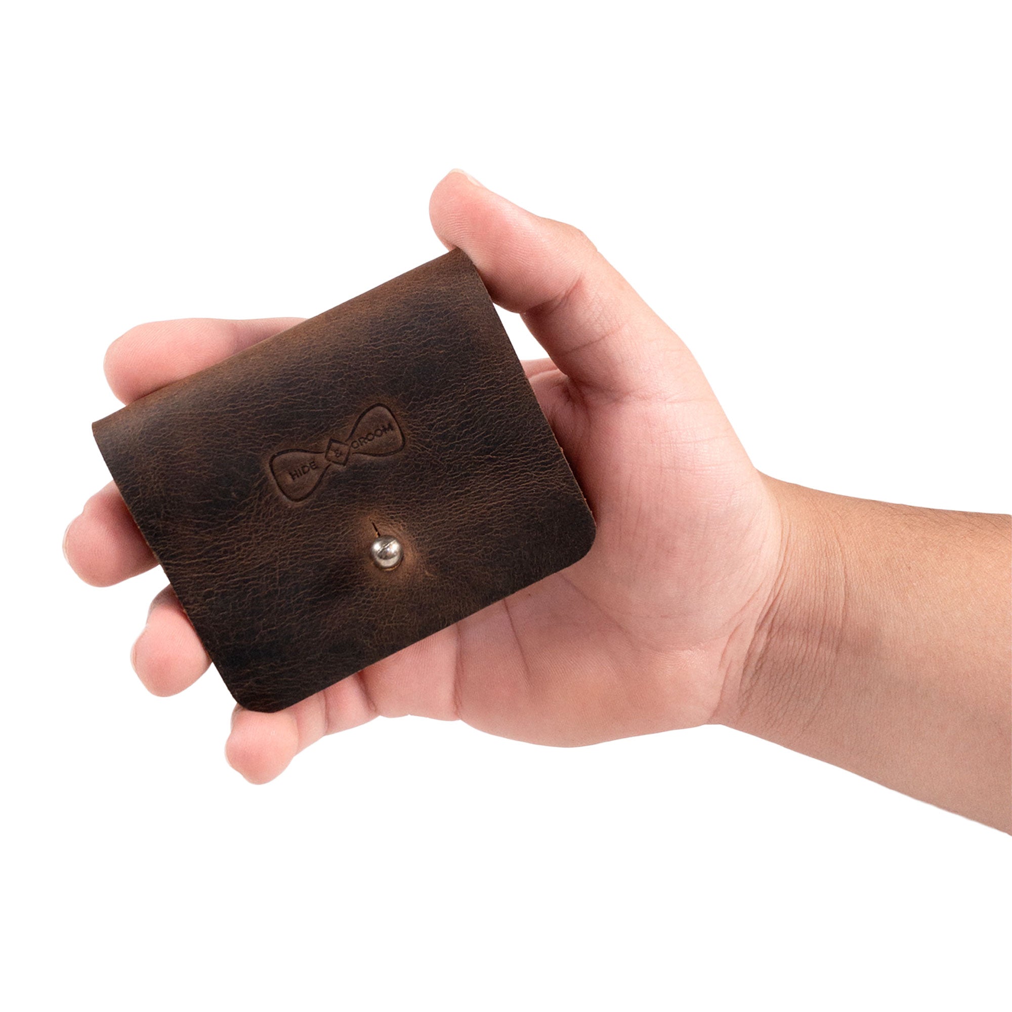 Collar Stays Organizer by Hide & Groom displayed in a hand, demonstrating its portable design and artisan craftsmanship. This rustic collar stays case is ideal for groomsmen, best man, and special ceremonies, made from full grain leather in small batches.